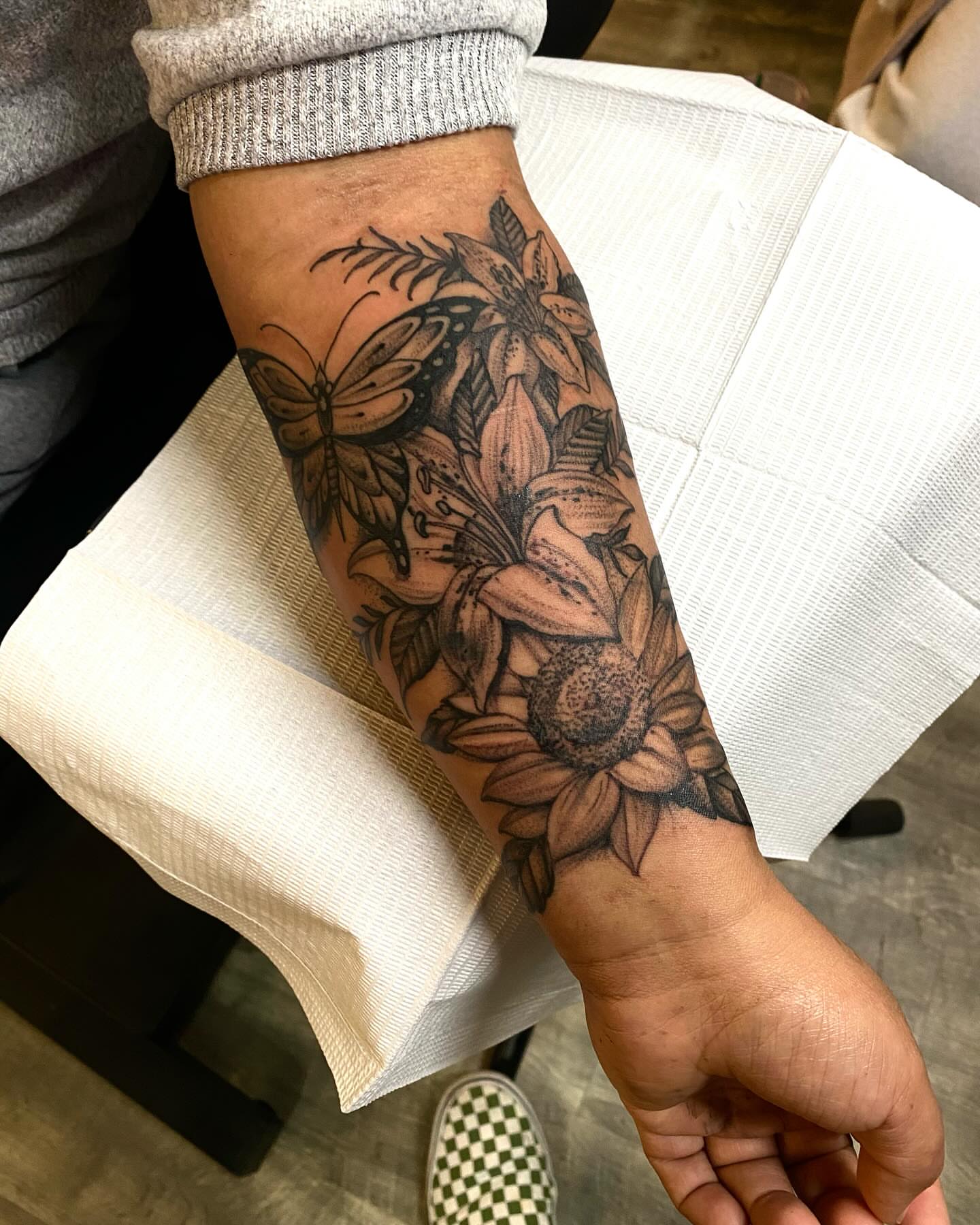 Sunflower and floral bouquet black and grey tattoo on the forearm by Chase Skylar Clayton Ogle