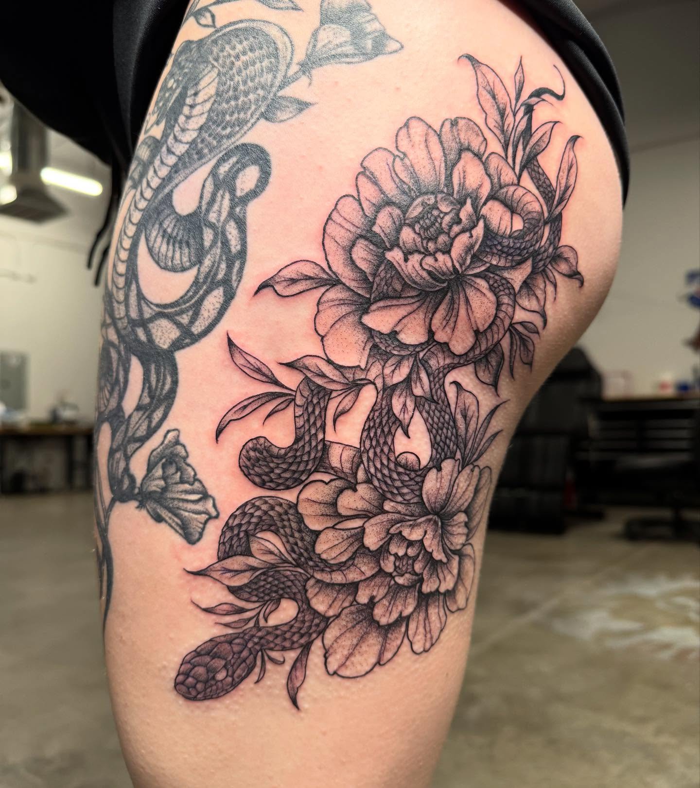 Snake and peony black and grey tattoo on the thigh by Cory Perry-Servellon