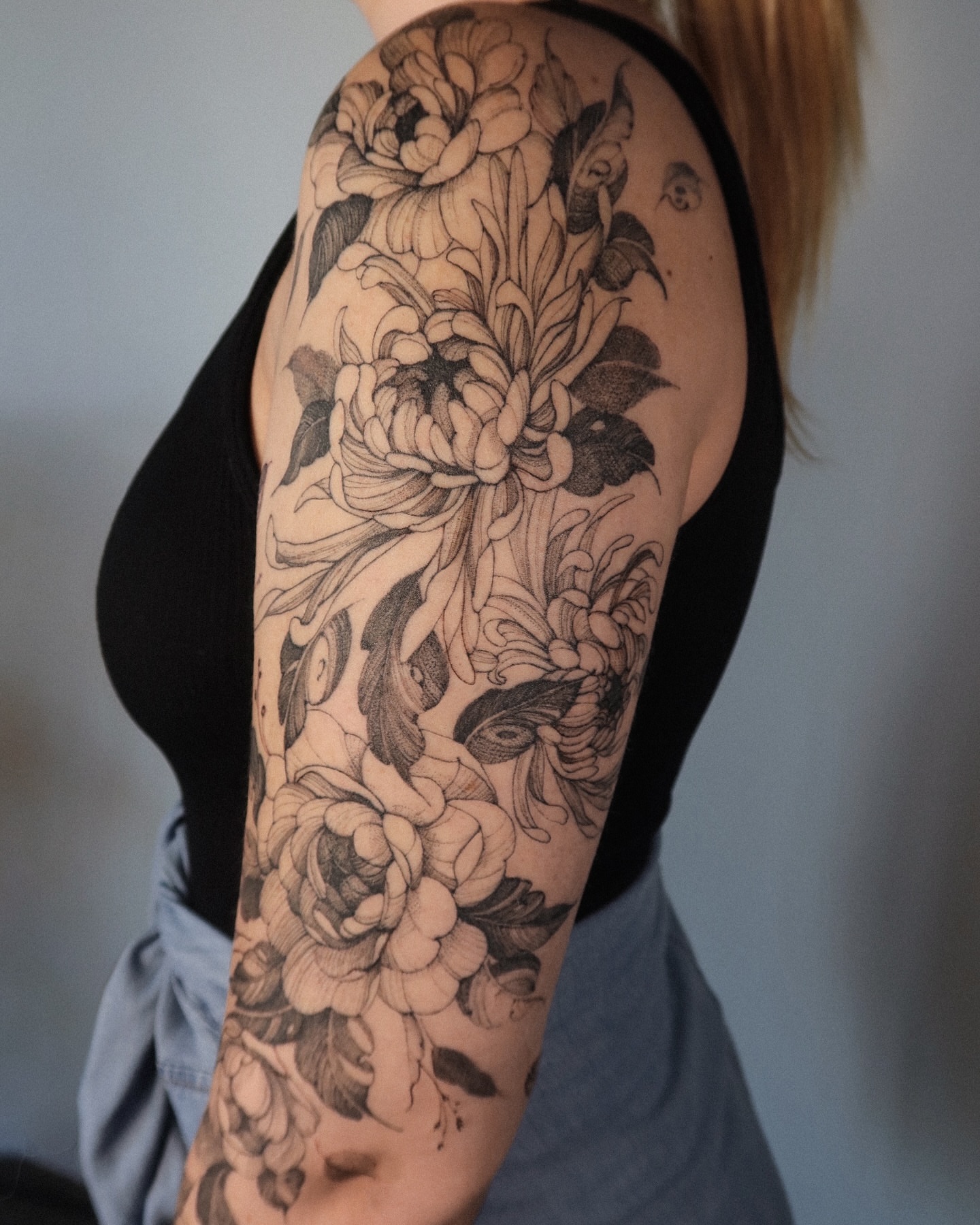 Floral bouquet black and grey tattoo on the upper arm by Maria