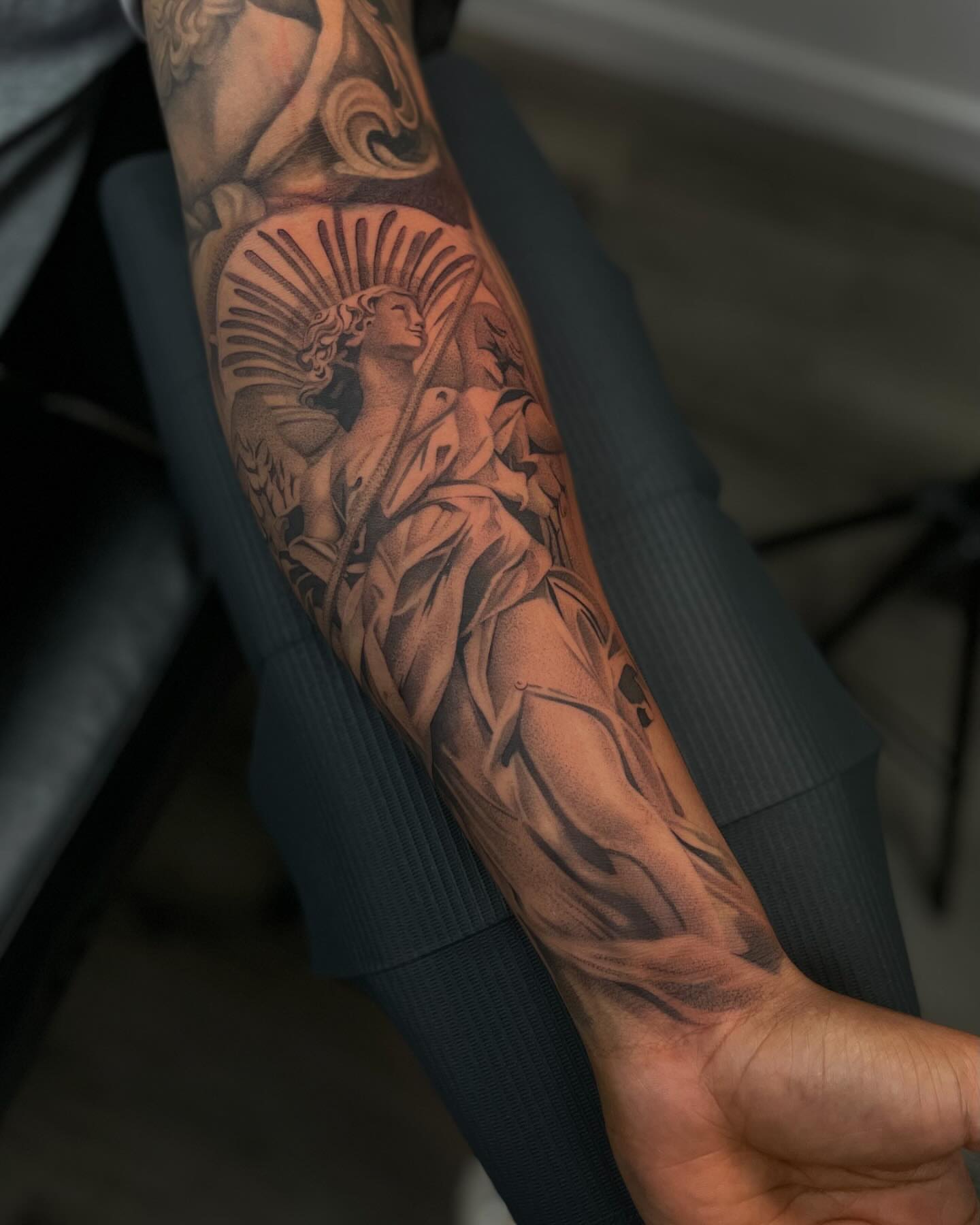 Statue of woman with wings realism tattoo on the forearm by Vanessa Valdivia