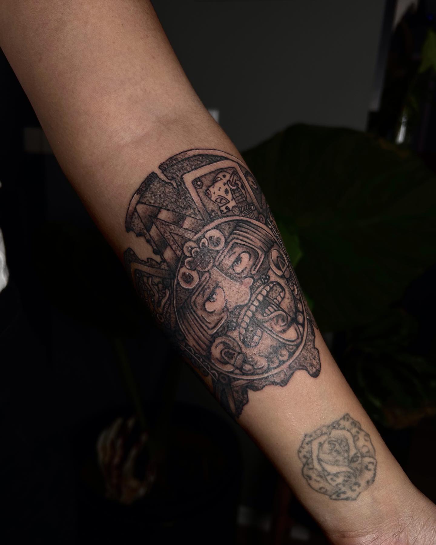 Mask black and grey tattoo on the forearm by Jelly