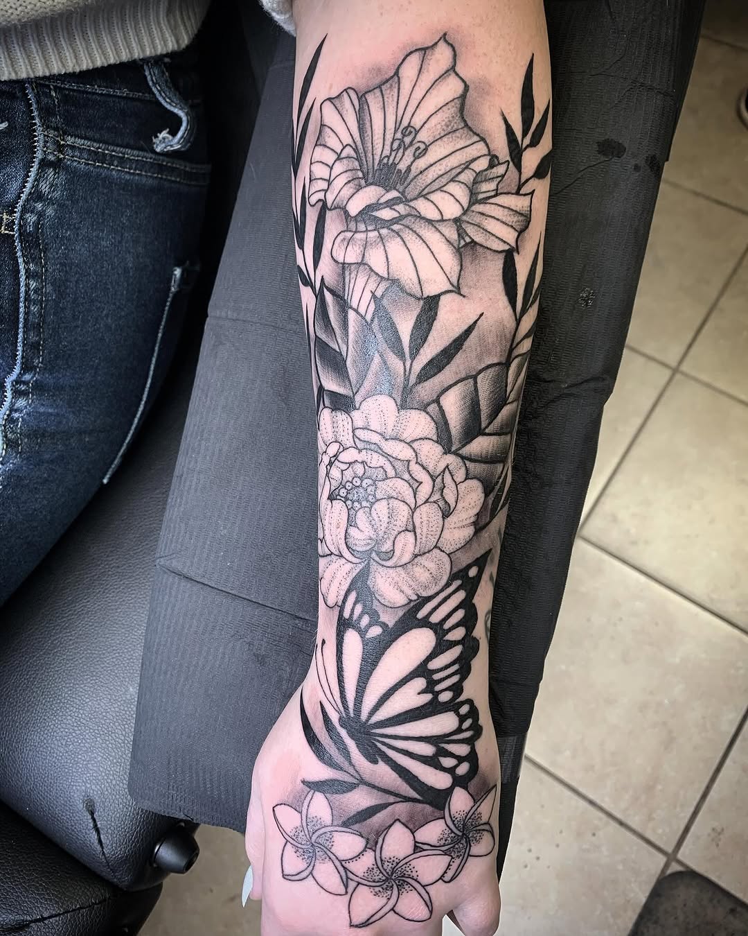 Butterfly and flowers dotwork tattoo on the forearm by El Kapitan
