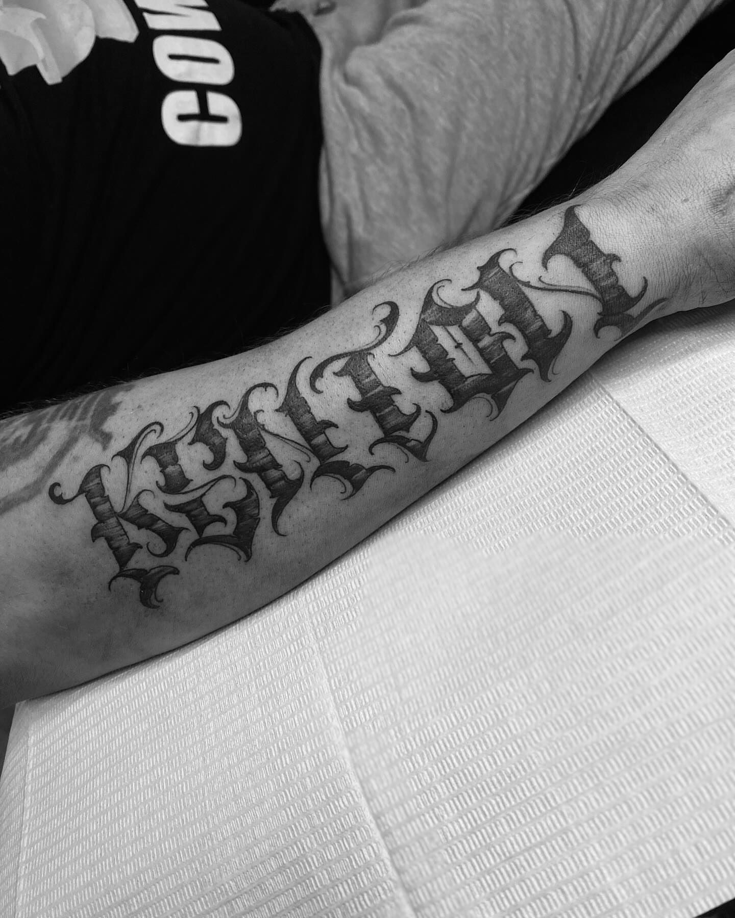 Gothic script black and grey tattoo on the forearm by Chase Skylar Clayton Ogle