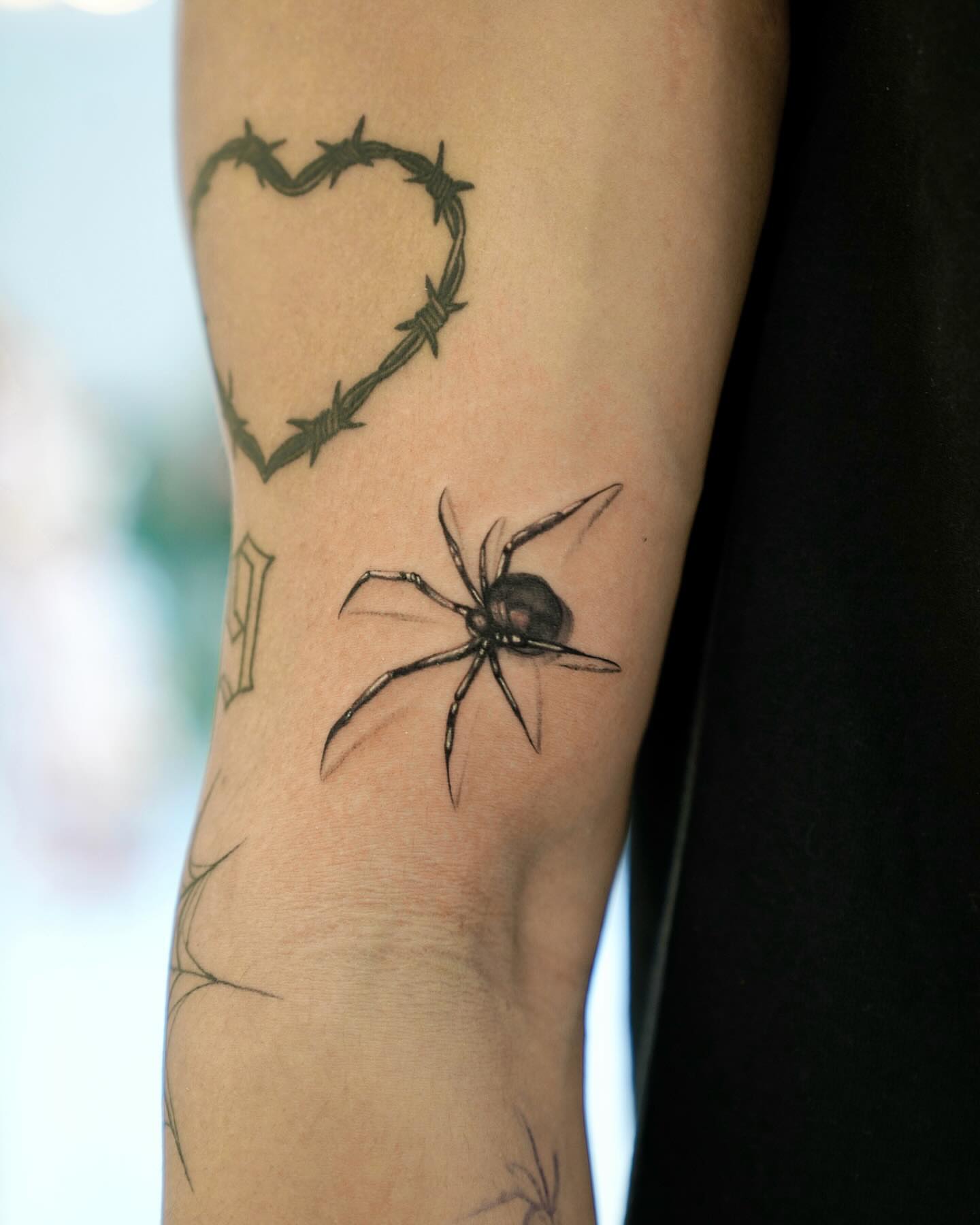 Barbed wire heart and spider realism tattoo on the forearm by David H.