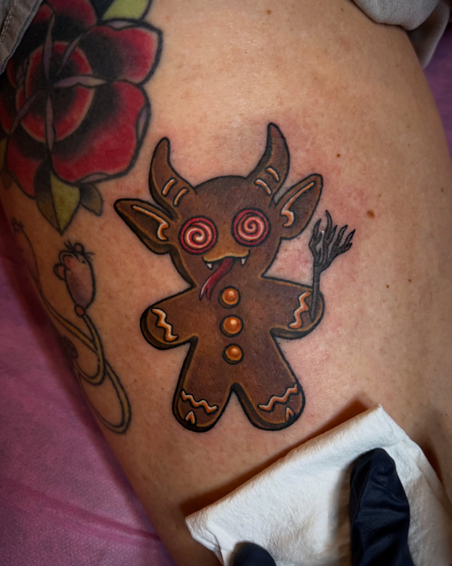Gingerbread man American traditional tattoo on the thigh by Alexandra Fische