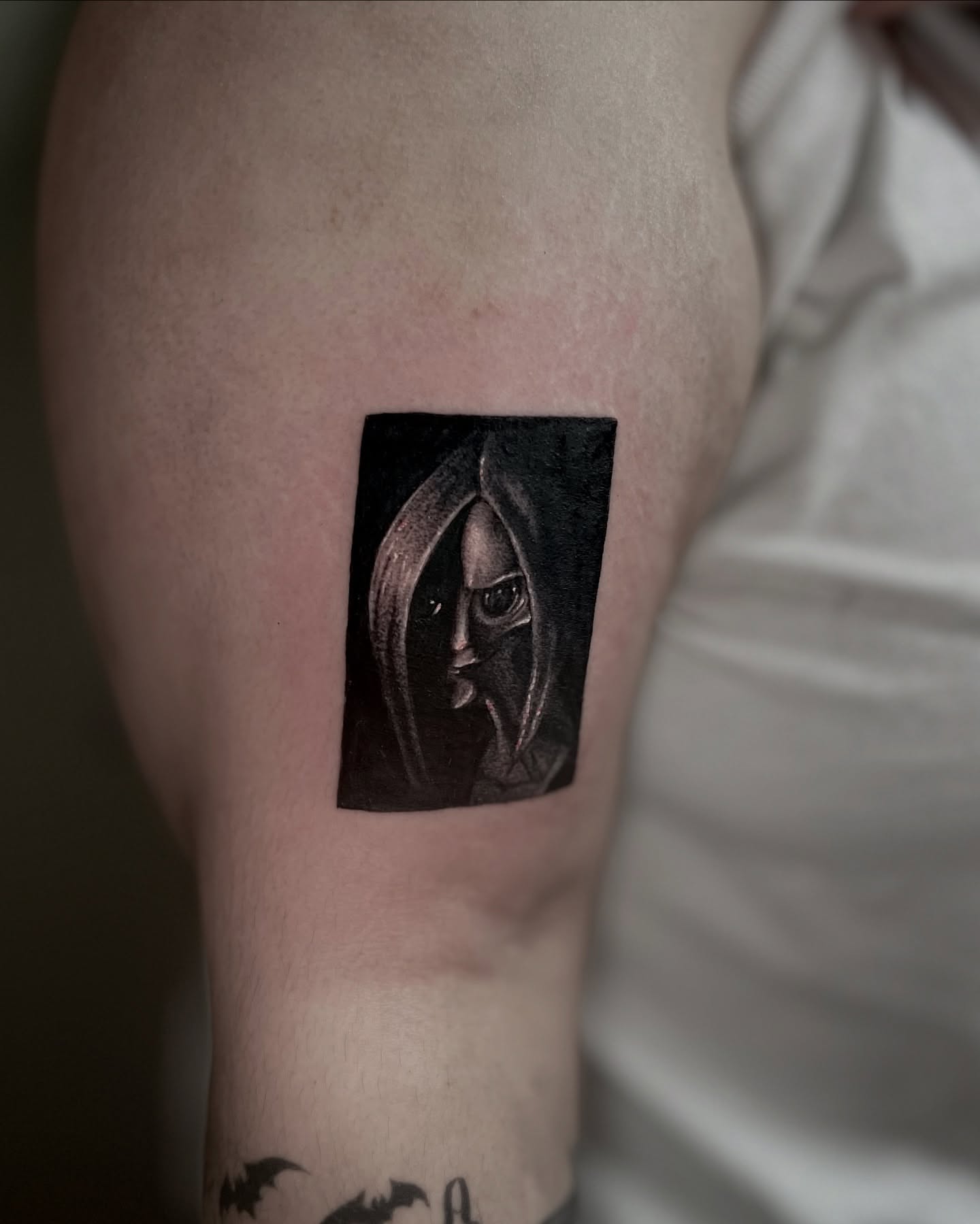 Hooded figure dark realism tattoo on the forearm by Bryan