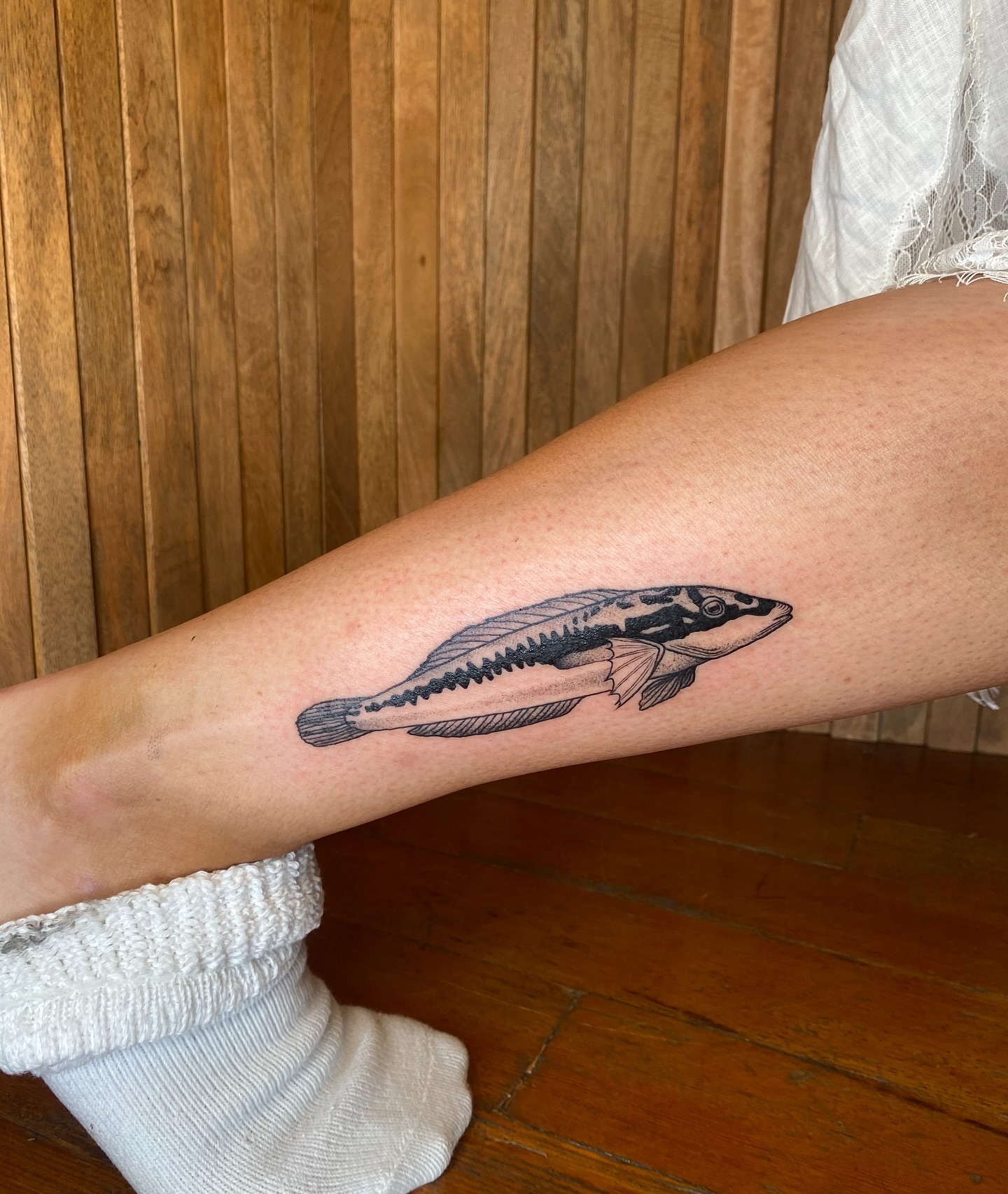 Fish black and grey tattoo on the forearm by Avery Kane