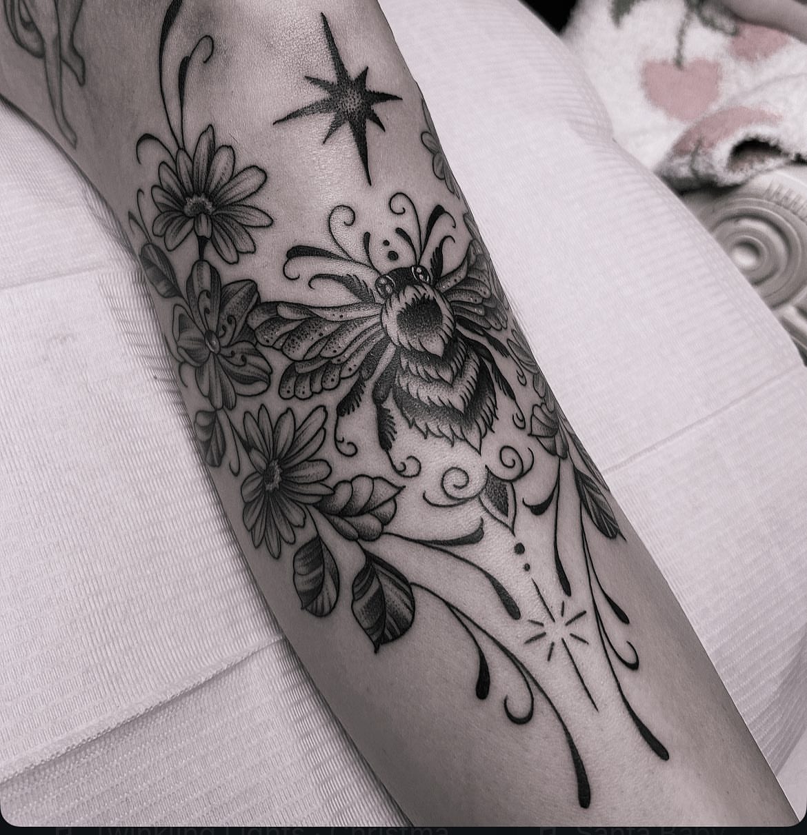 Butterfly and flowers black and grey tattoo on the forearm by Anna Nicole Thomas