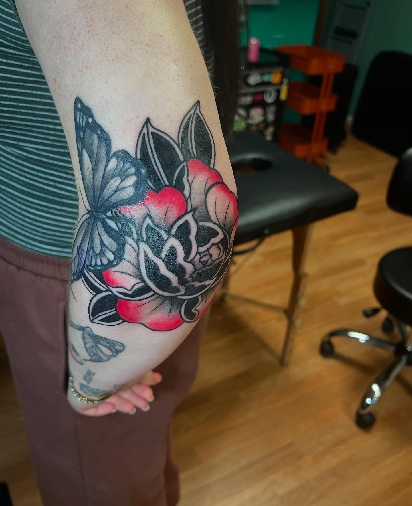 Flower and butterfly American traditional tattoo on the forearm by Katie Sayre