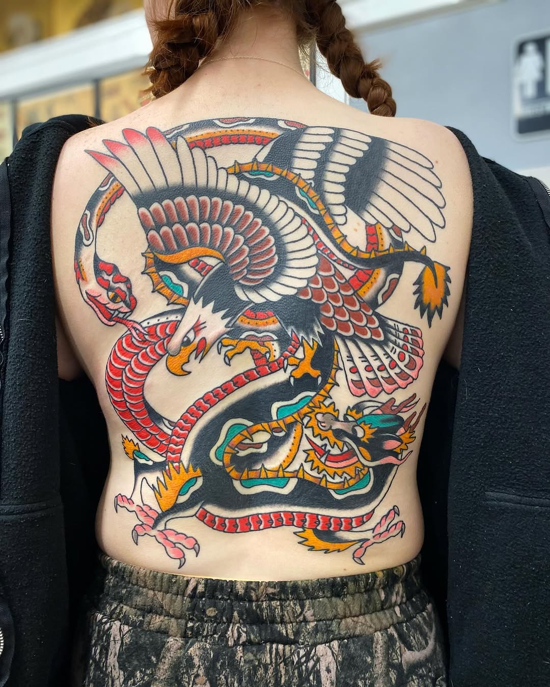 Eagle fighting dragon American traditional tattoo on the back by @rubber_band_dan, San Francisco, California
