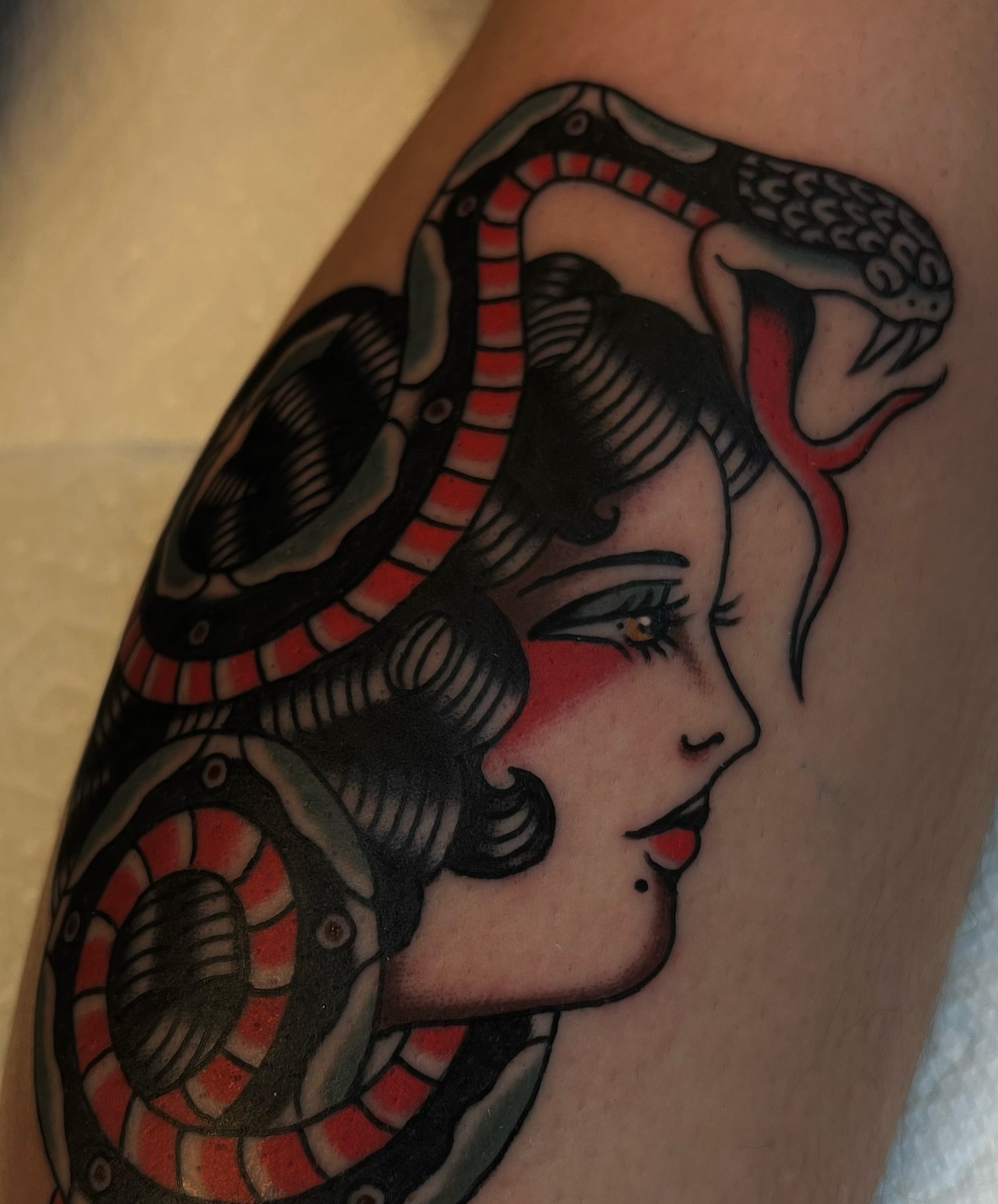 Woman with snake American traditional tattoo on the forearm by Syd Sayyah