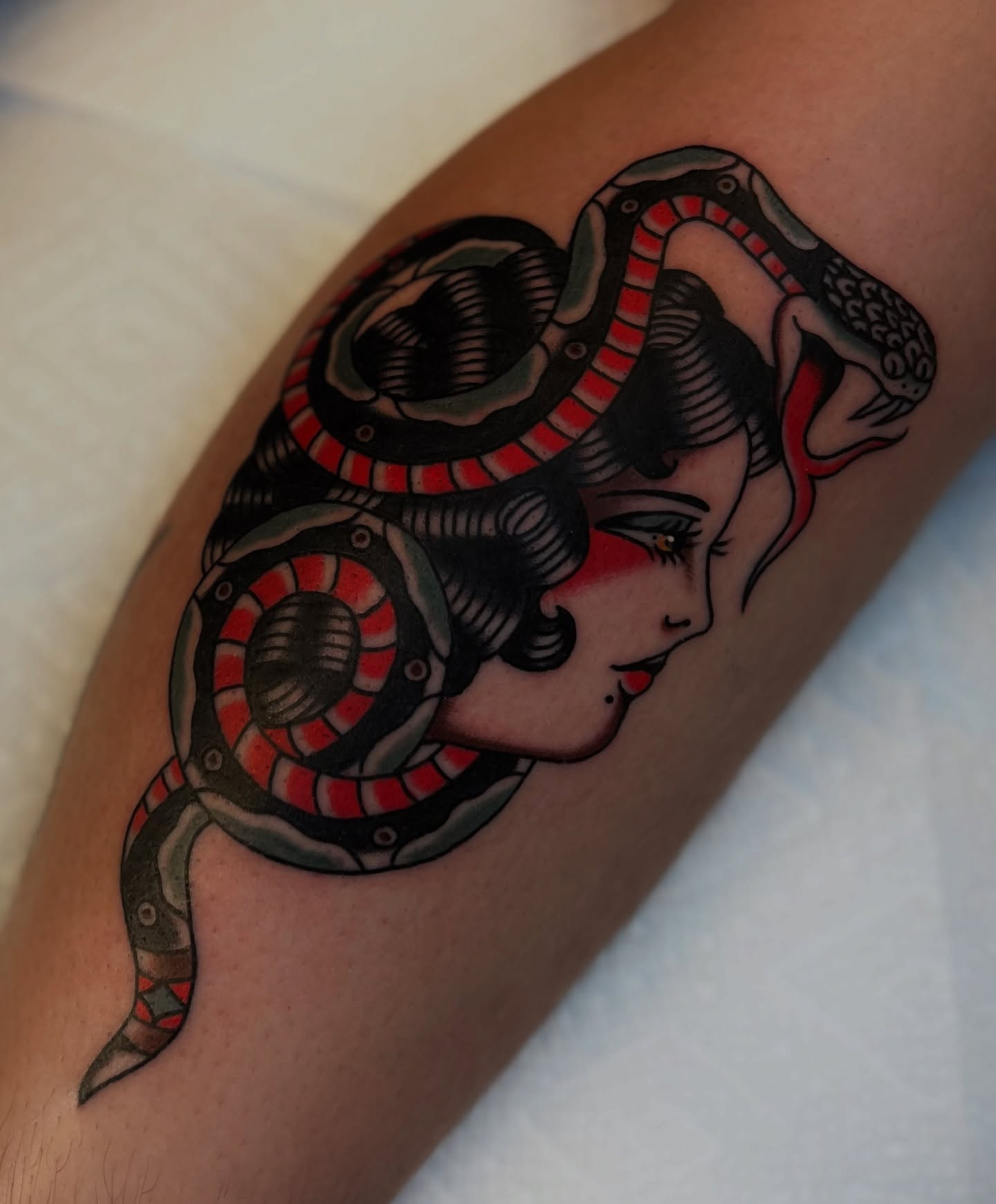 Woman with snake American traditional tattoo on the forearm by Syd Sayyah