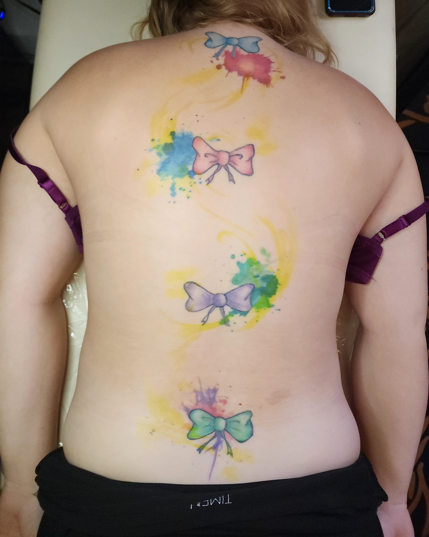 Bow watercolor tattoo on the back by ✨Vii Duquette✨