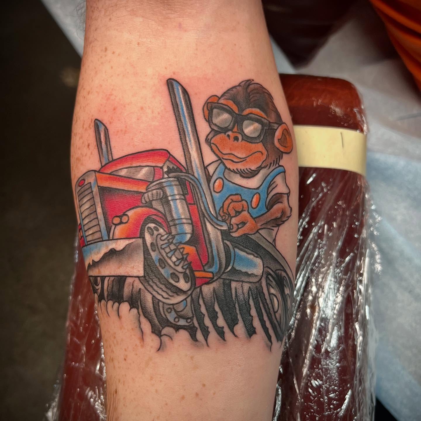 Monkey driving truck American traditional tattoo on the forearm by Dustin Hysell