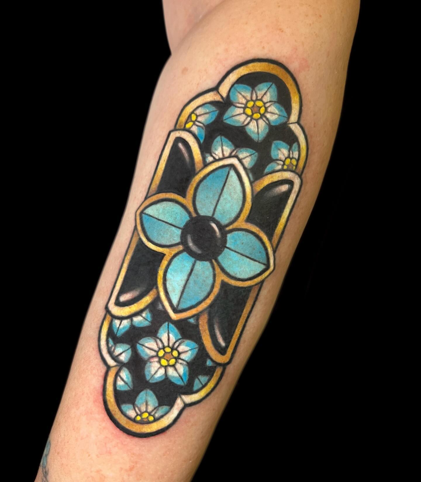 Blue flowers American traditional tattoo on the forearm by Cortney Norton