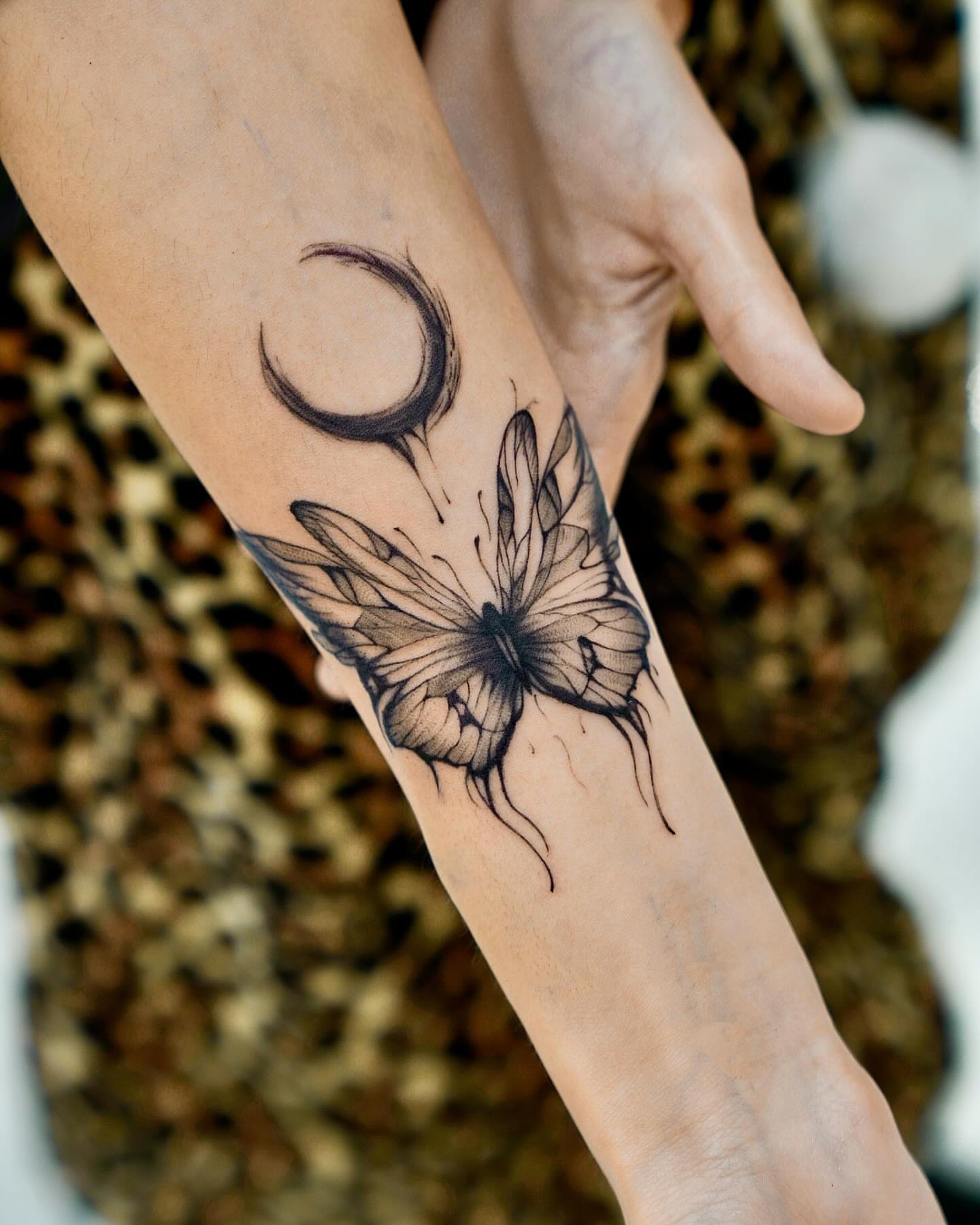Butterfly and moon dotwork tattoo on the forearm by David H.
