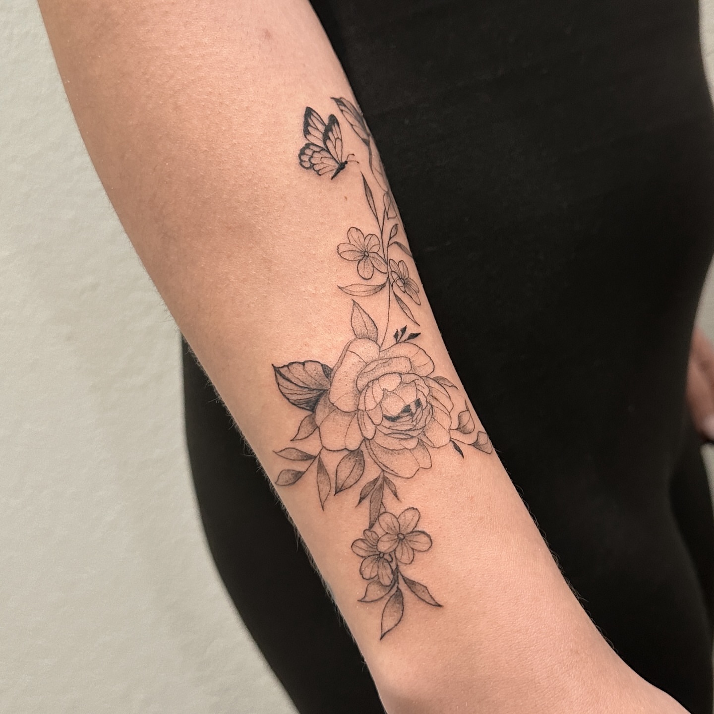 Floral arrangement black and grey tattoo on the forearm by Alex