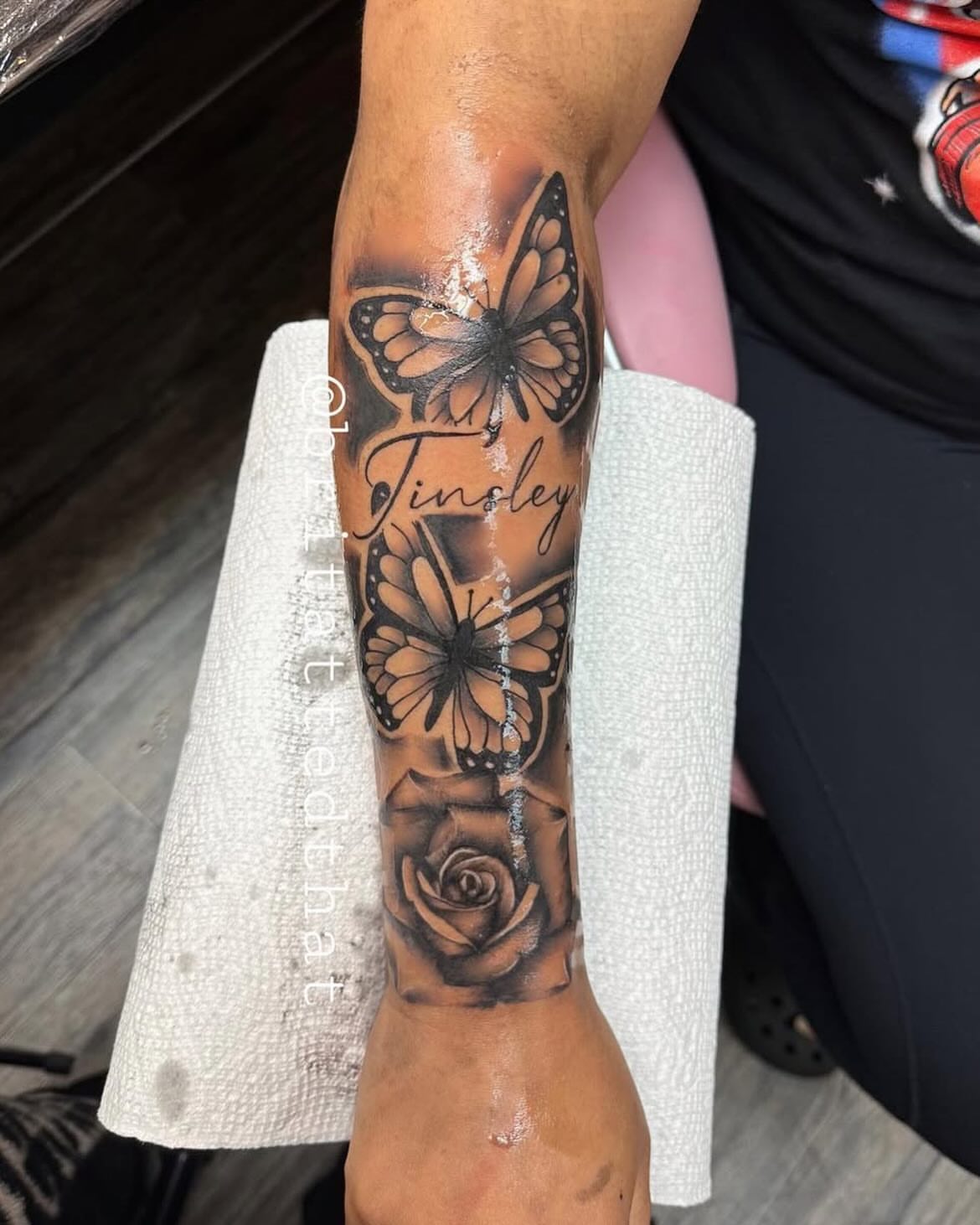 Butterfly and flower black and grey tattoo on the forearm by Bri Tatted That