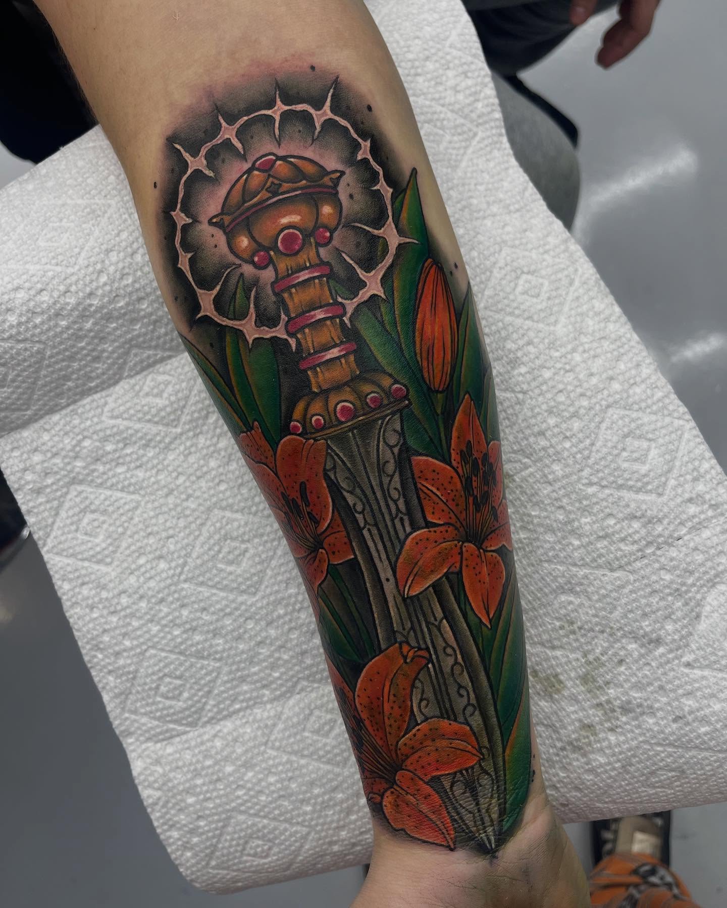Sword and lilies neo-traditional tattoo on the forearm by Autumn Fulford