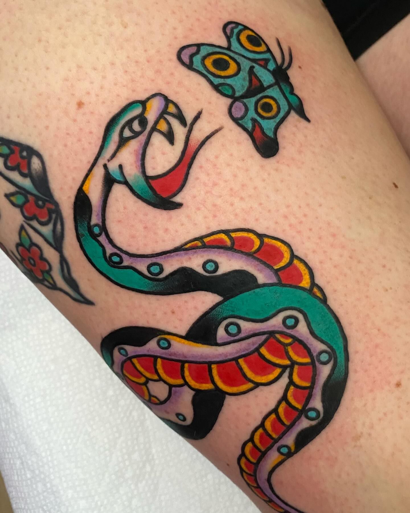 Snake and butterfly American traditional tattoo on the forearm by Shana