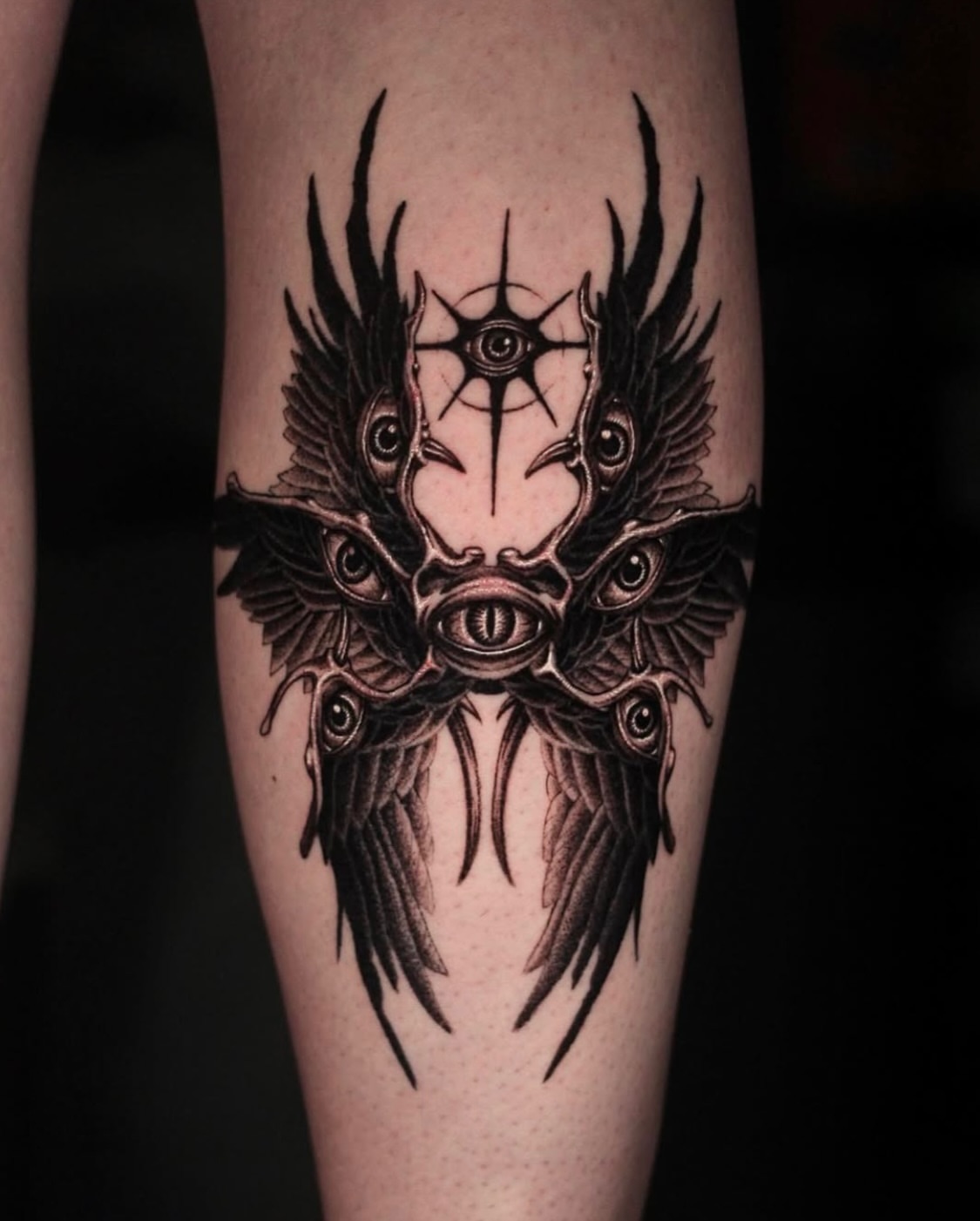 Eyes and wings geometric tattoo on the forearm by H.black