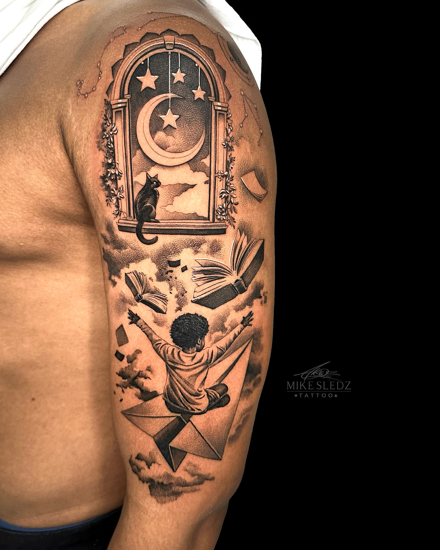 Book and sky realism tattoo on the upper arm by ✶ MIKE SLEDZ ✶ Chicago Tattoo Artist