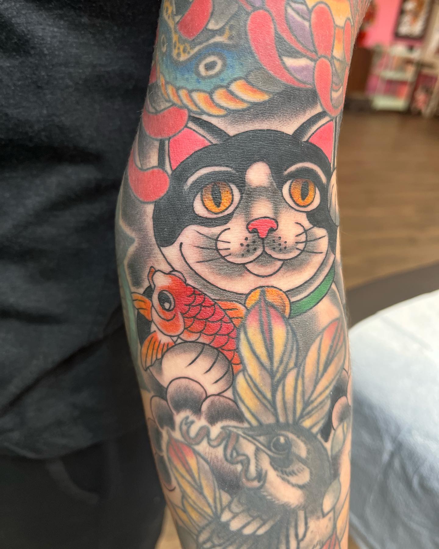 Cat and koi fish American traditional tattoo on the forearm by Cody Hanson