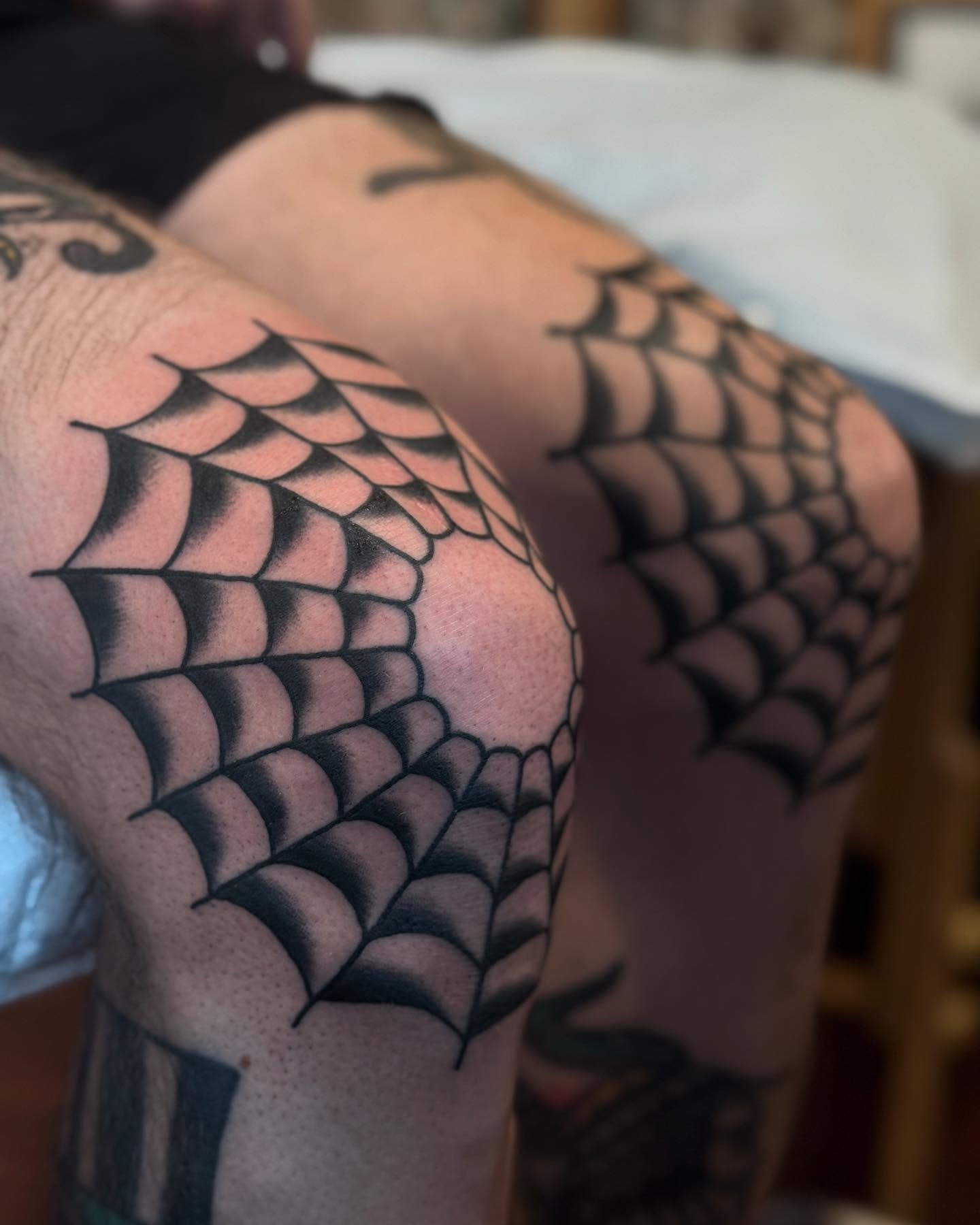 Spider web black and grey tattoo on the thigh by Ross K. Jones Tattoos, San Francisco, California