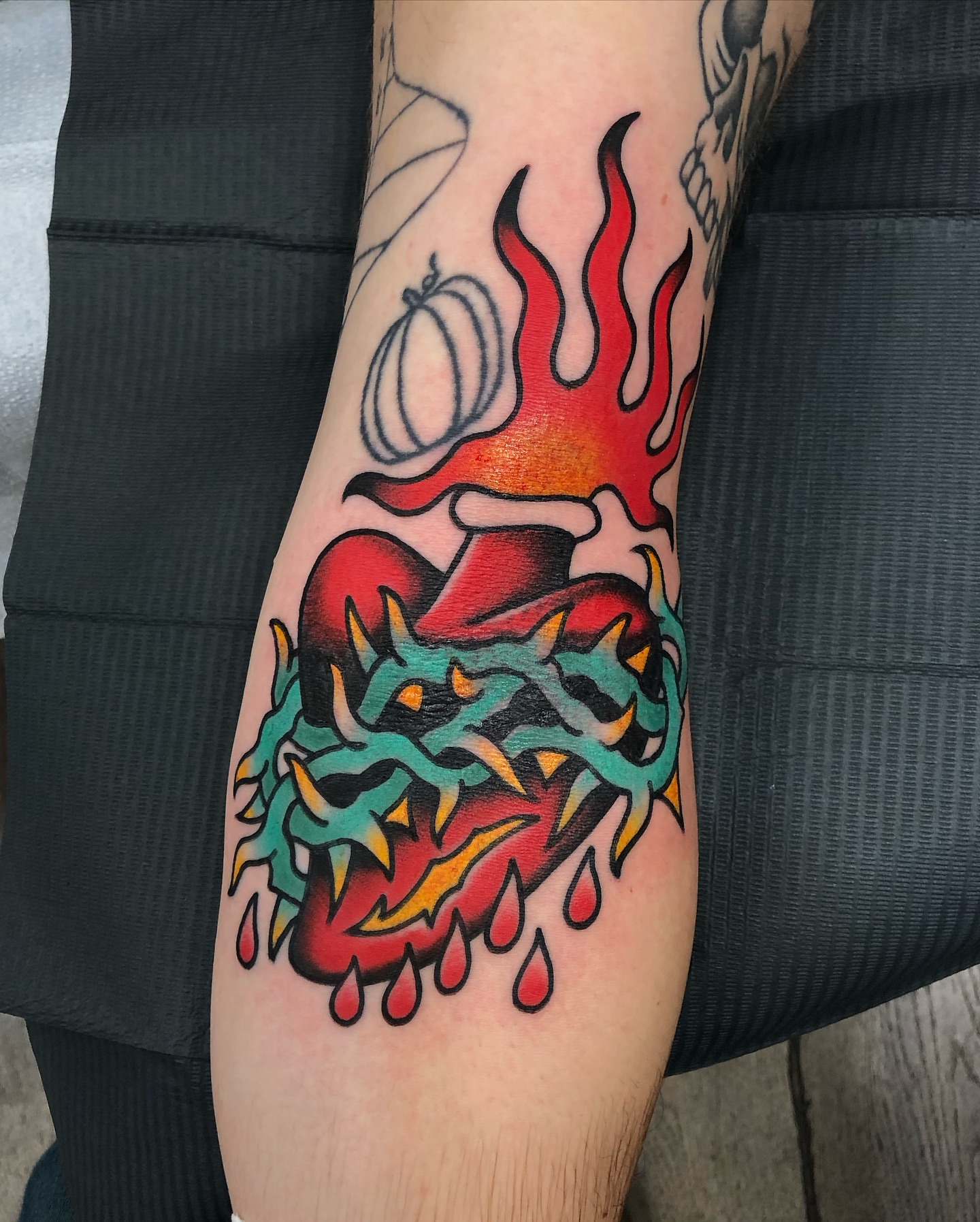 Heart with flames American traditional tattoo on the forearm by Nick Sharratt, Chicago, Illinois