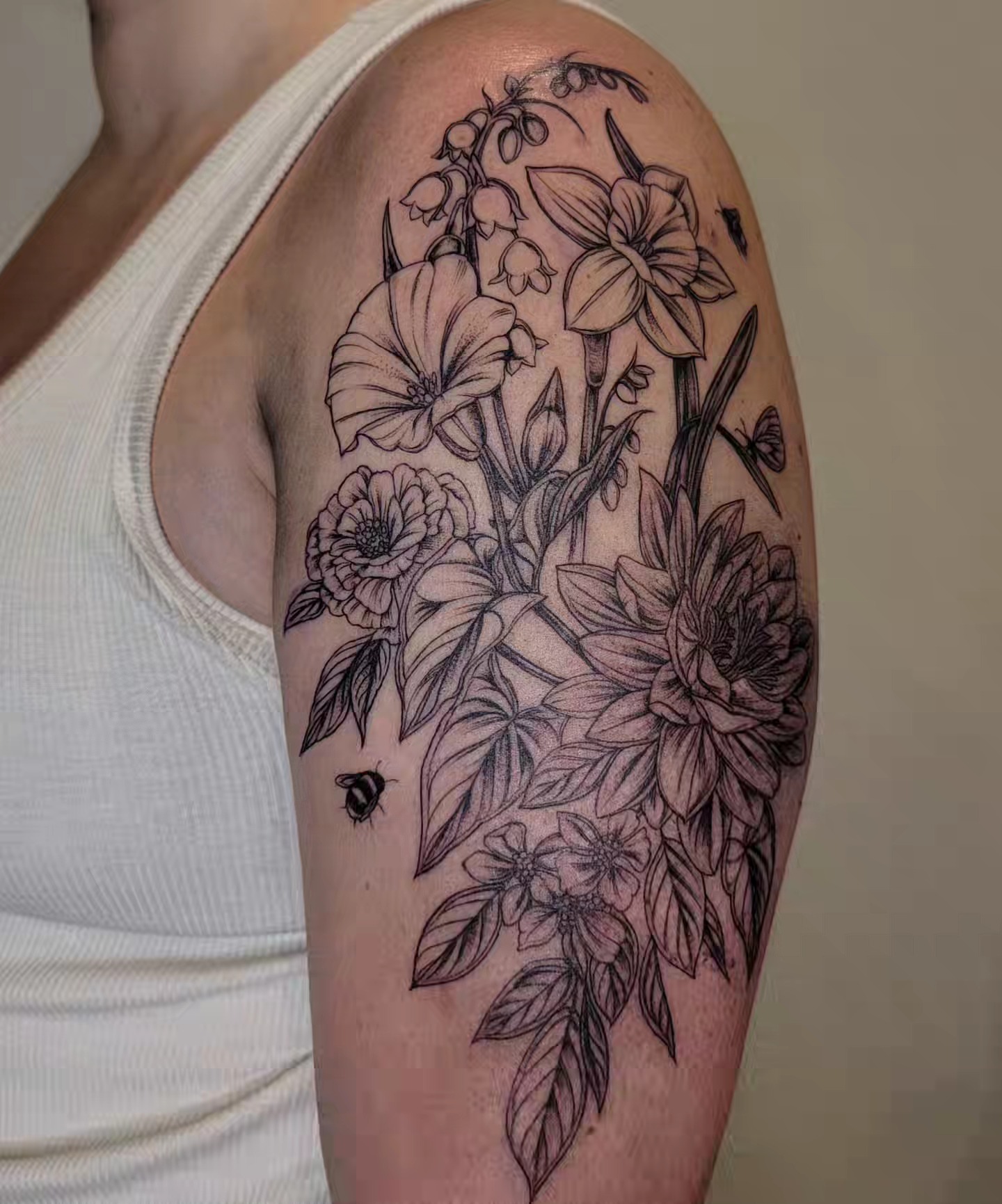 Floral bouquet realism tattoo on the upper arm by Sierra (cc) Klein