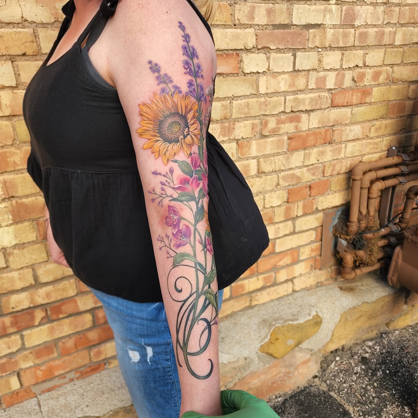 Sunflower and floral bouquet new school tattoo on the forearm by Alexander L. Wolff, Rapid City, South Dakota