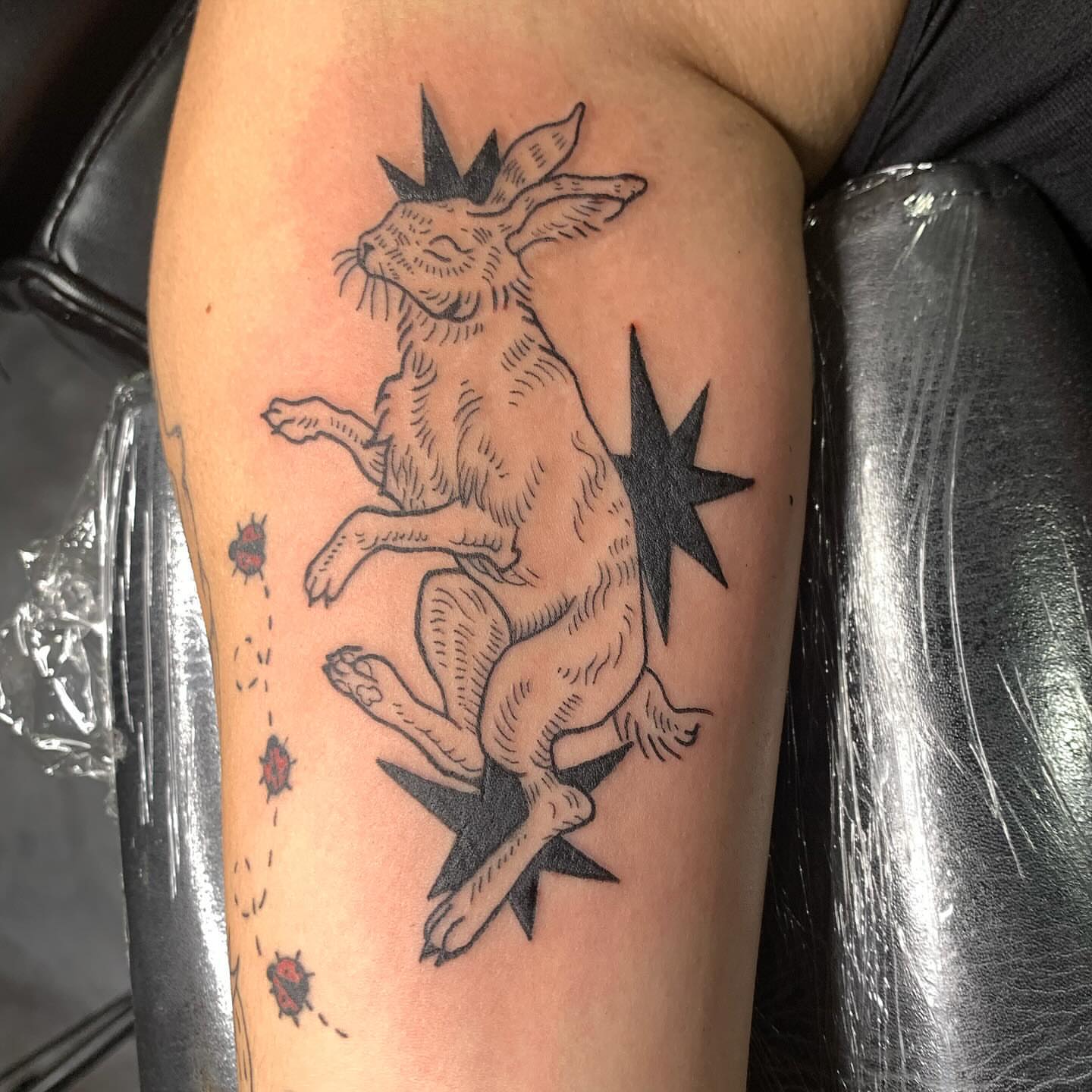 Jumping rabbit black and grey tattoo on the forearm by Ava Glory Tattoos