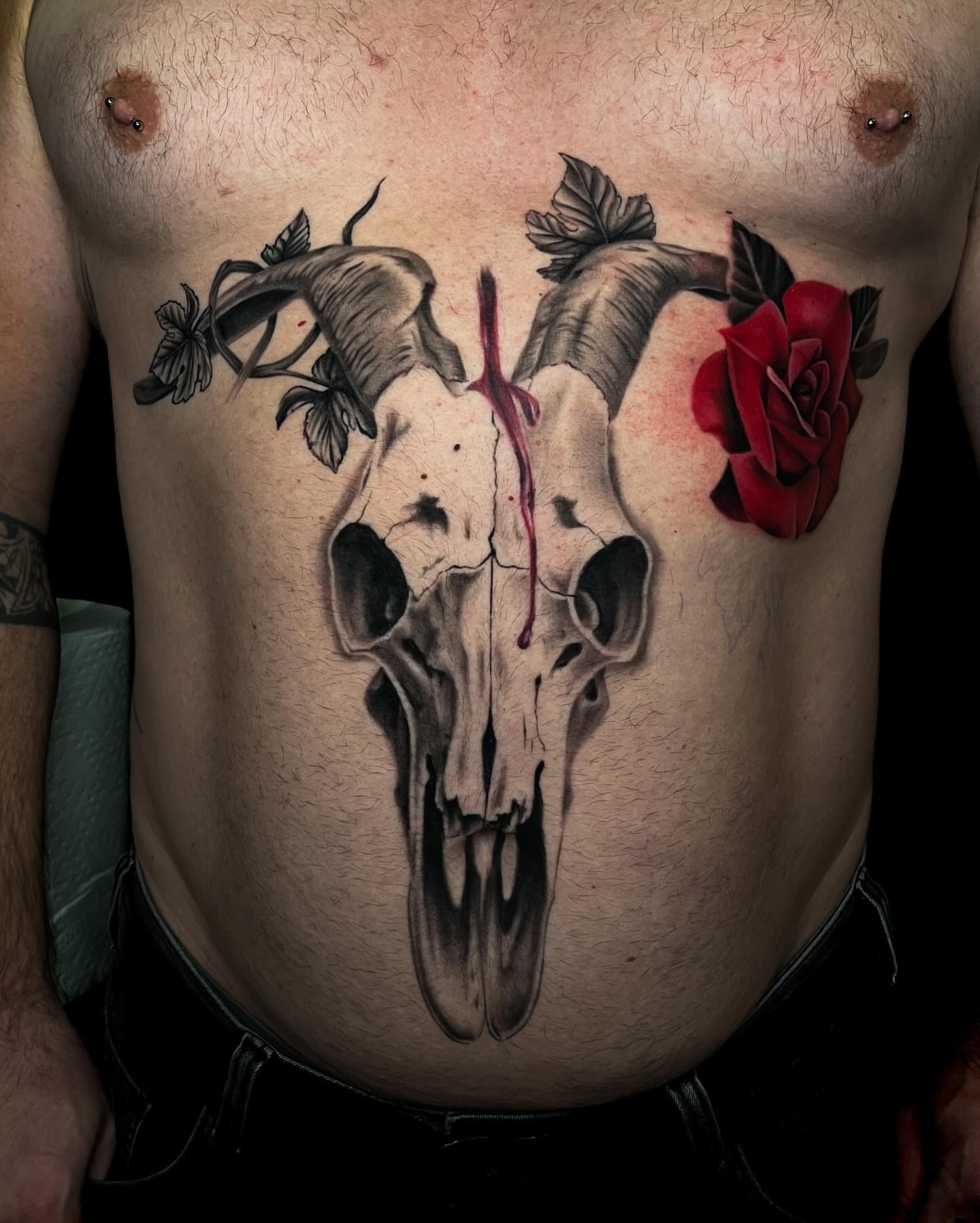 Skull and rose realism tattoo on the chest by Demi DiMartino