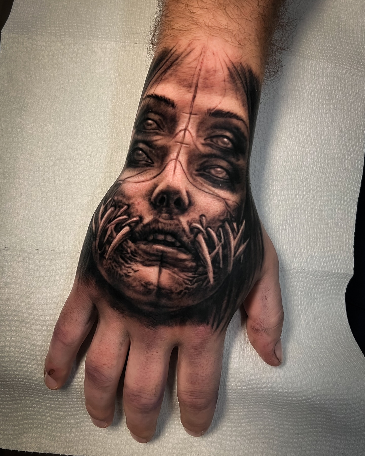 Horror face dark realism tattoo on the hand by Aaron, Milwaukee, Wisconsin