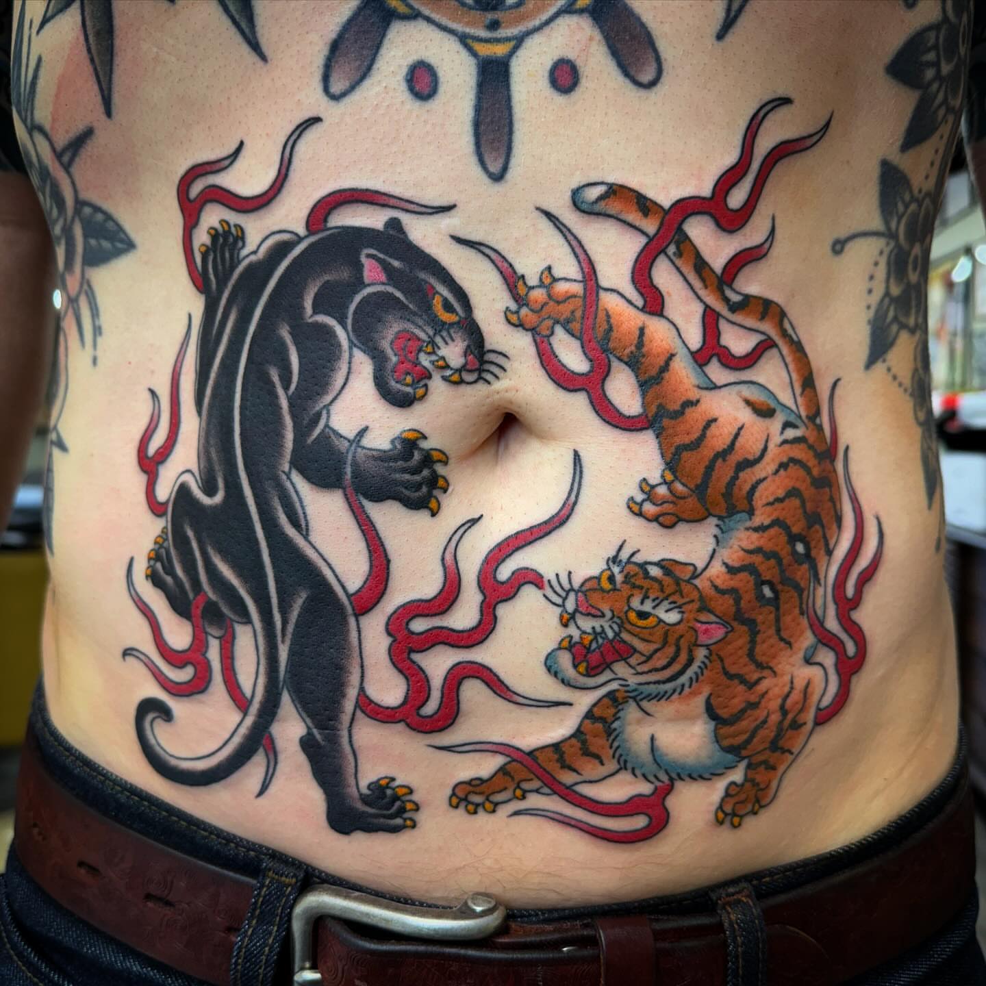 Panther and tiger American traditional tattoo on the ribs by Ethan Bennett