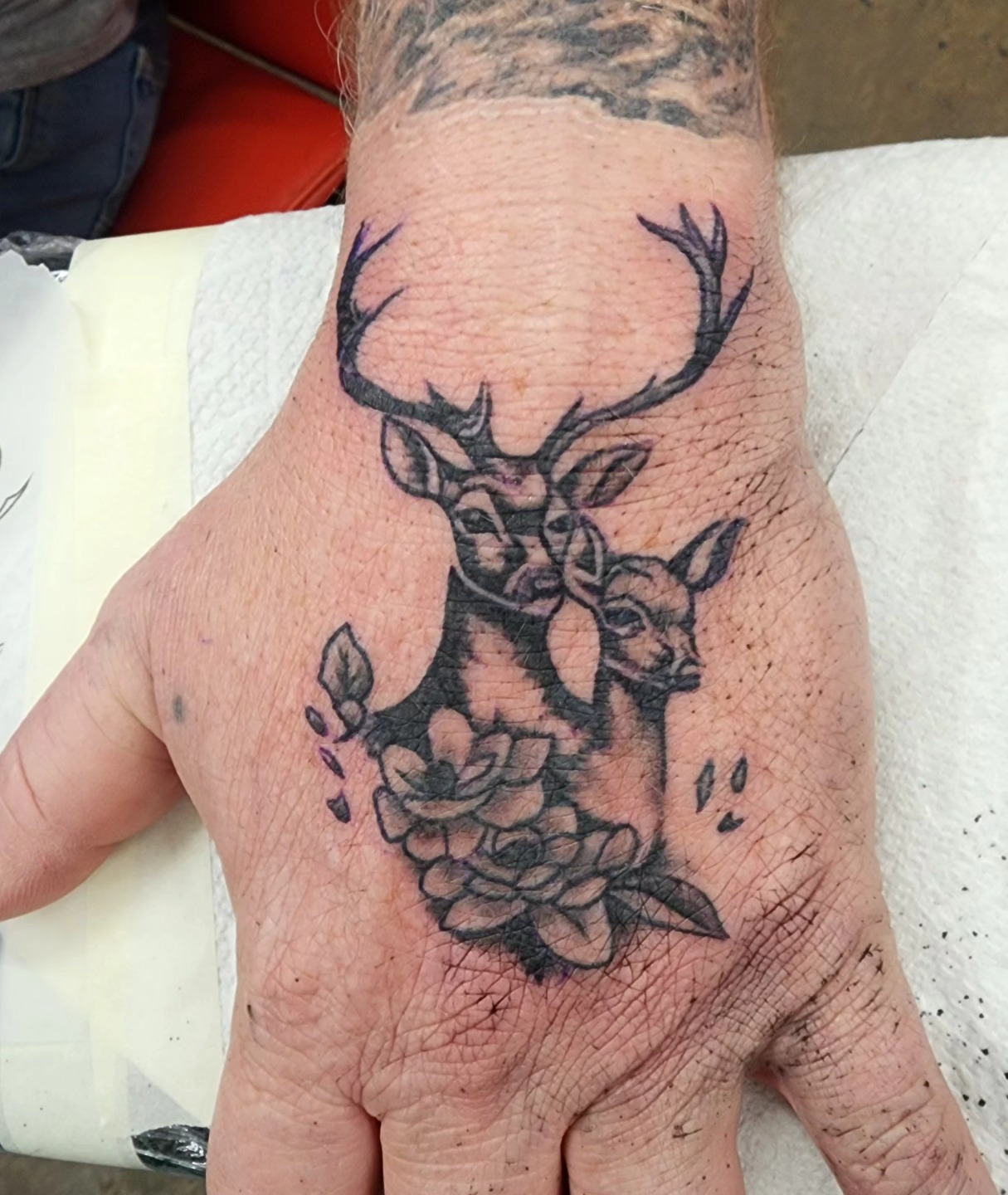Deer and flowers black and grey tattoo on the hand by @thedevilspaintbrush_