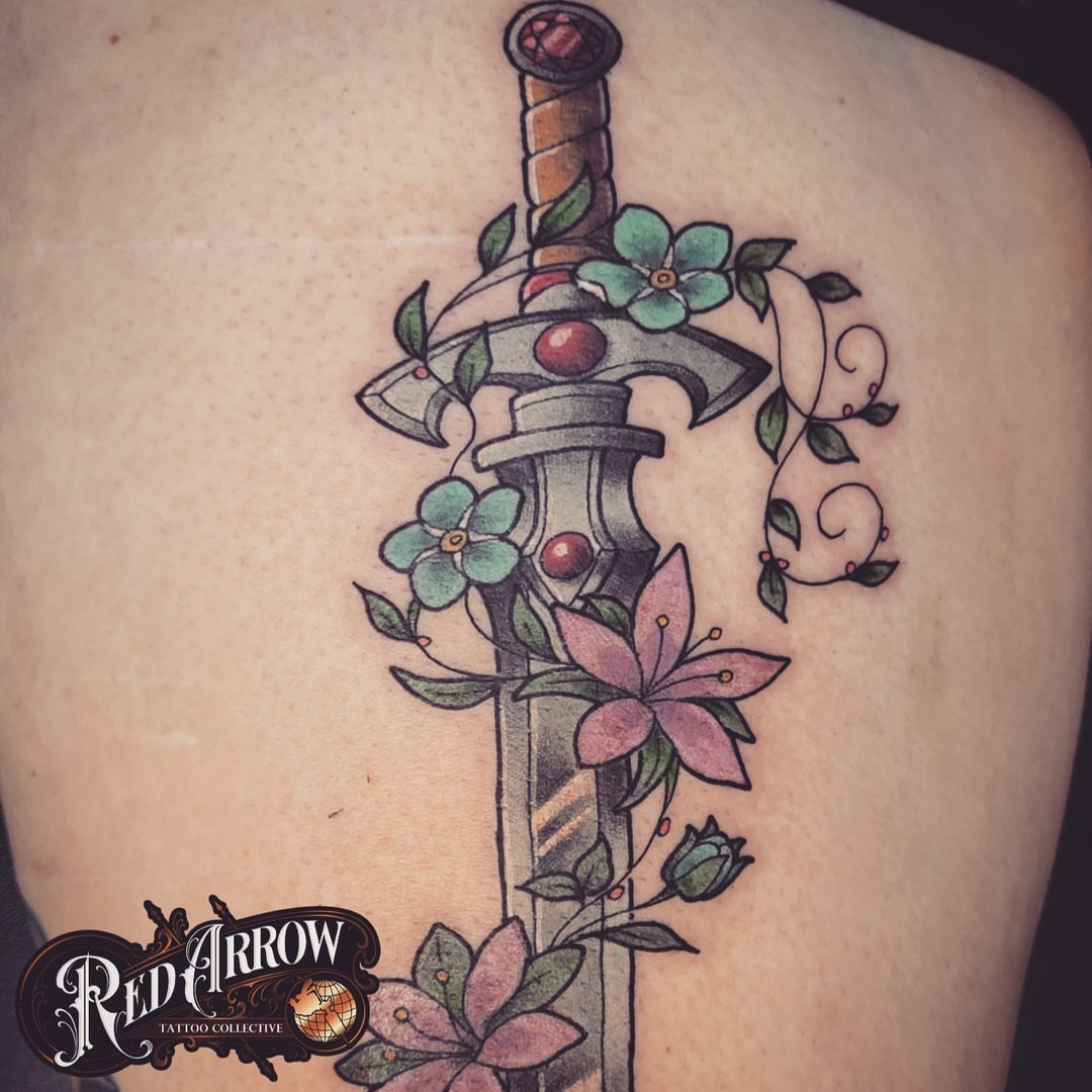 Sword and flowers American traditional tattoo on the back by 𝕽𝖊𝖉 𝕬𝖗𝖗𝖔𝖜 𝕿𝖆𝖙𝖙𝖔𝖔 𝕮𝖔𝖑𝖑𝖊𝖈𝖙𝖎𝖛𝖊, Troy, Michigan