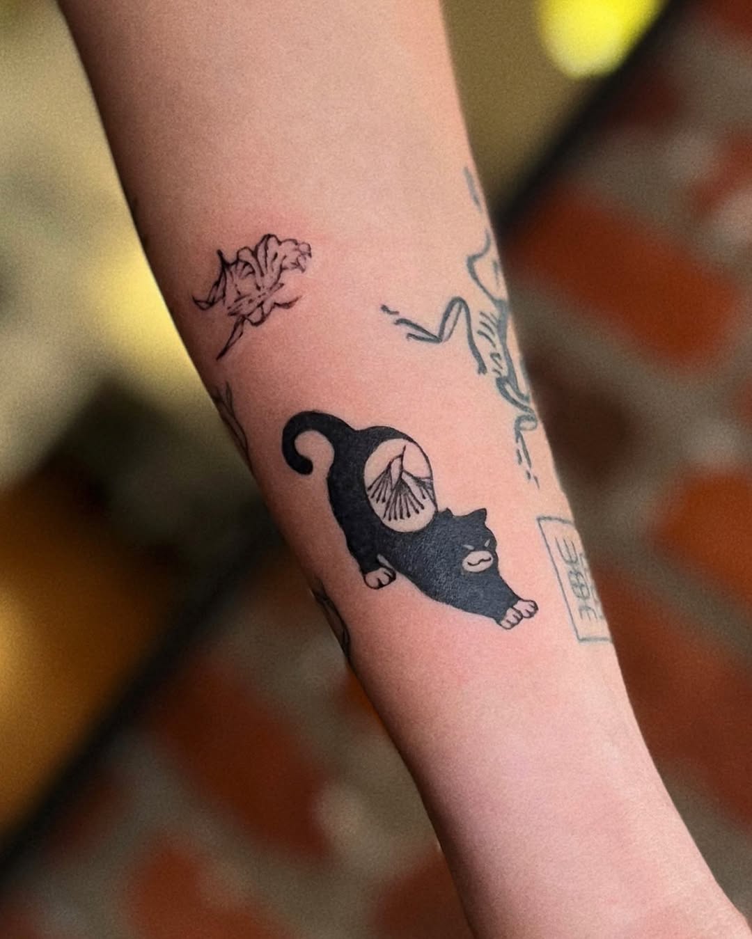 Stretching cat realism tattoo on the forearm by San Kang