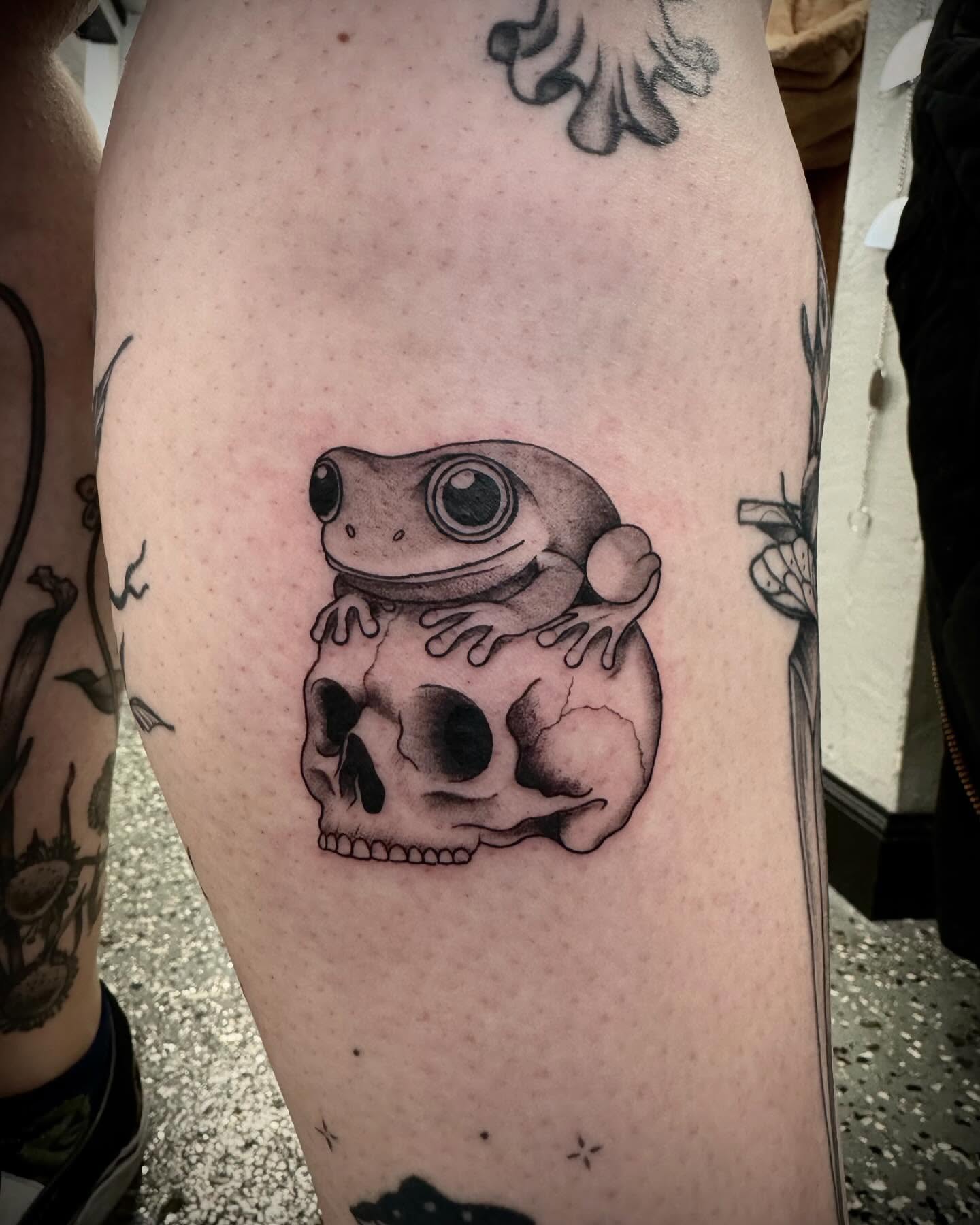 Frog and skull black and grey tattoo on the thigh by oh hey, robin.