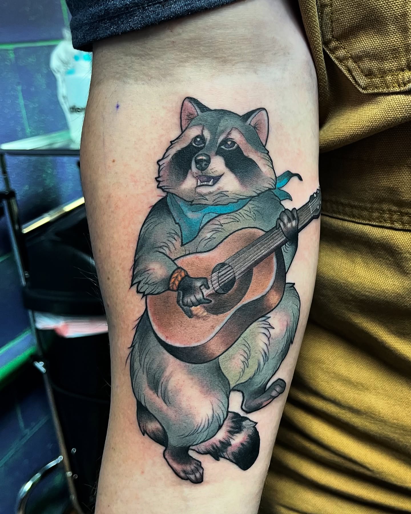 Raccoon playing guitar realism tattoo on the thigh by Angelique Sanders, Tellico Plains, Tennessee