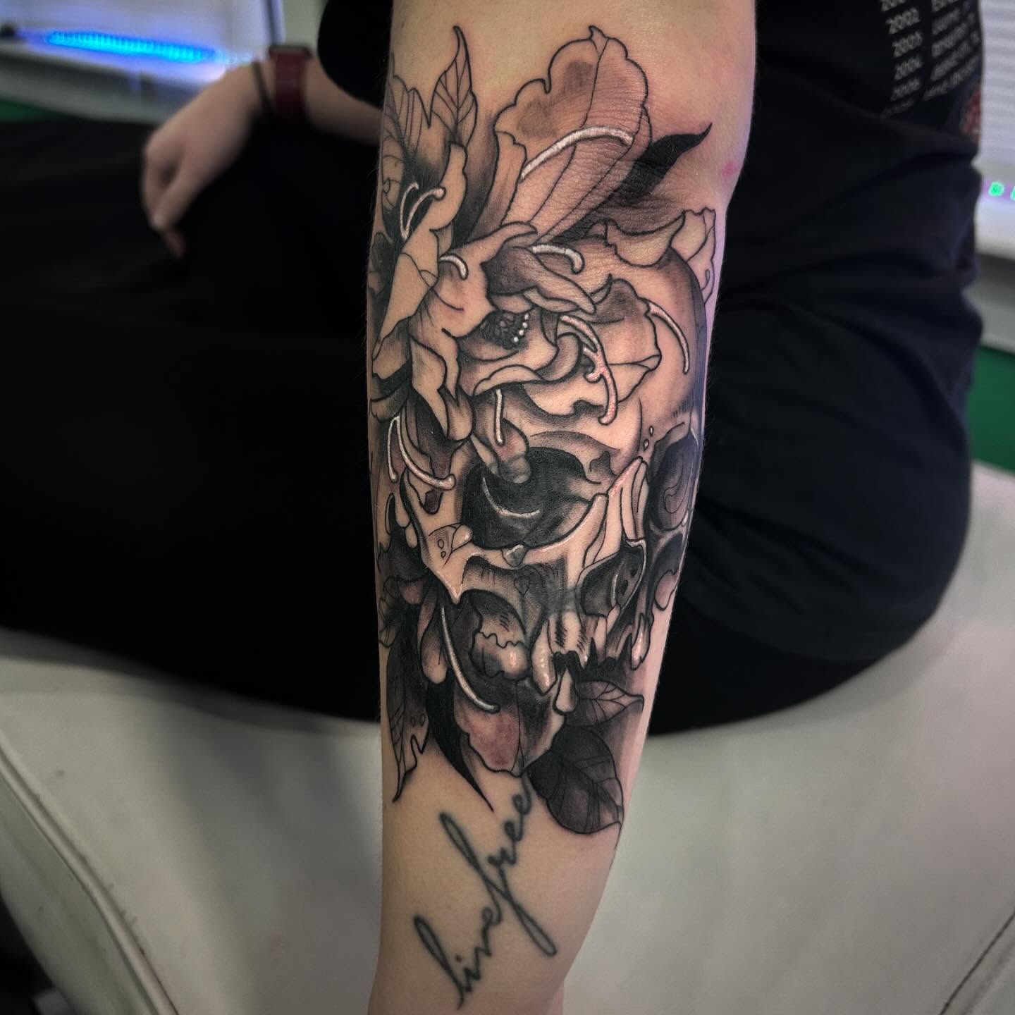 Floral skull realism tattoo on the forearm by Haley Winfree