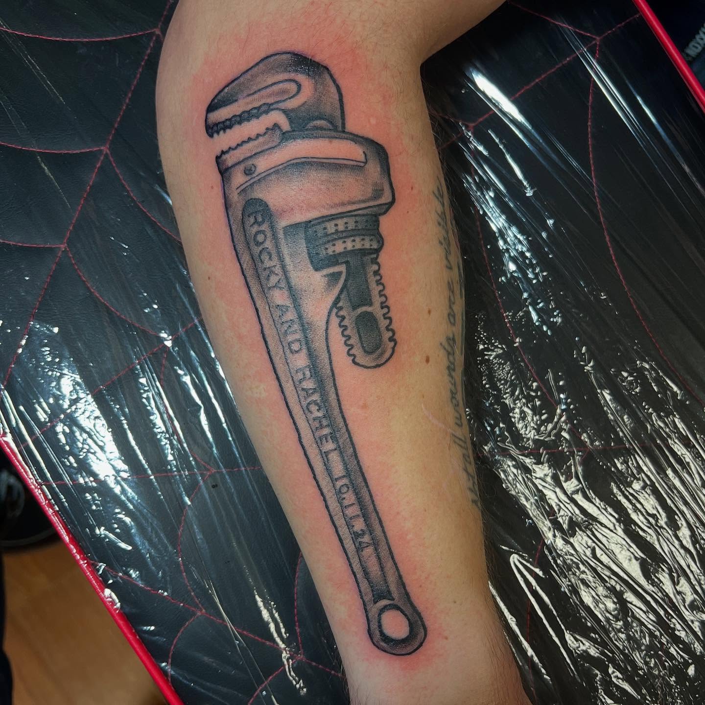 Pipe wrench black and grey tattoo on the forearm by Katie Sayre