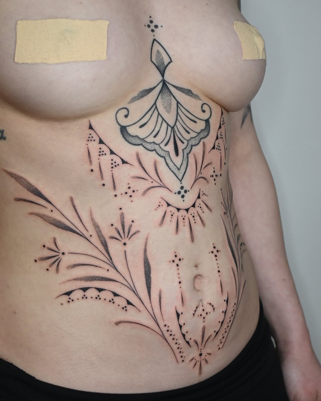 Floral design dotwork tattoo on the torso by Simba Nguyen