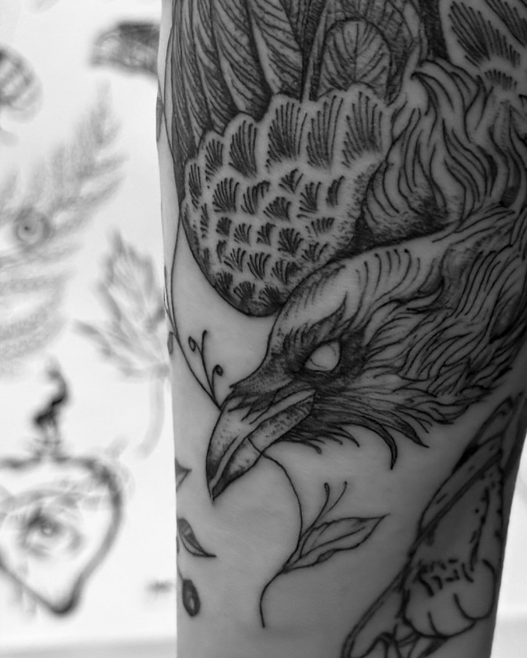 Raven with foliage fine line tattoo on the forearm by Thylacine Tattoo & Art, Los Angeles, California