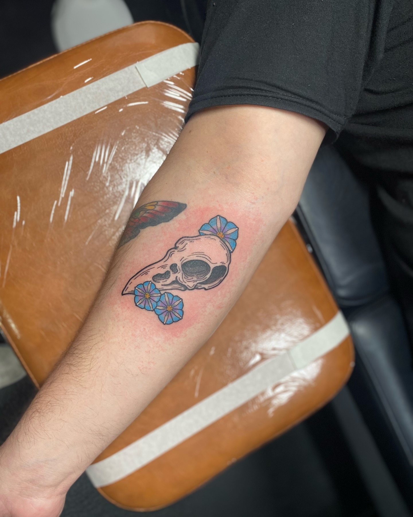 Skull with flowers new school tattoo on the forearm by S C O T T