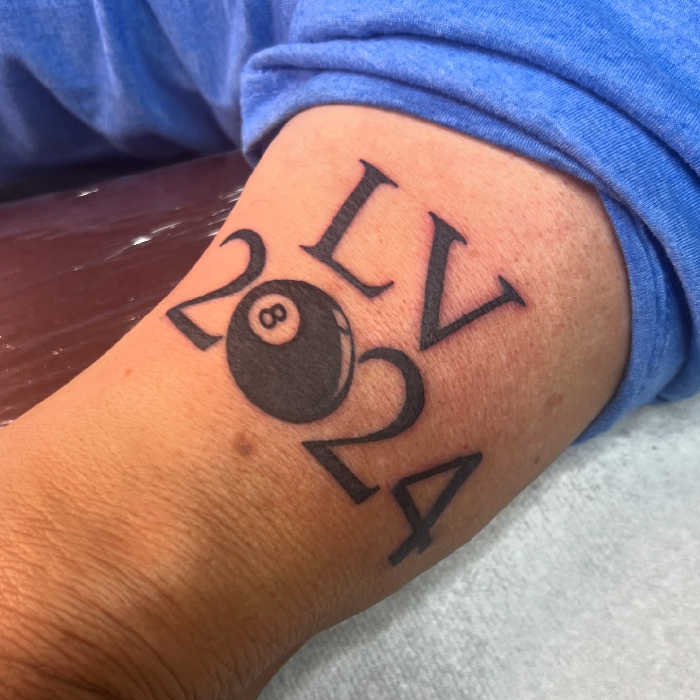 8-ball and year black and grey tattoo on the forearm by Nick Ochoa