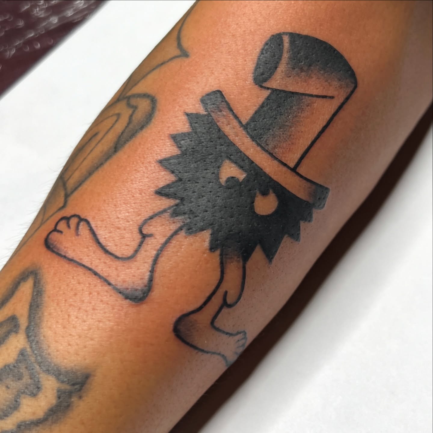 Hat and sun black and grey tattoo on the forearm by Nick Ochoa