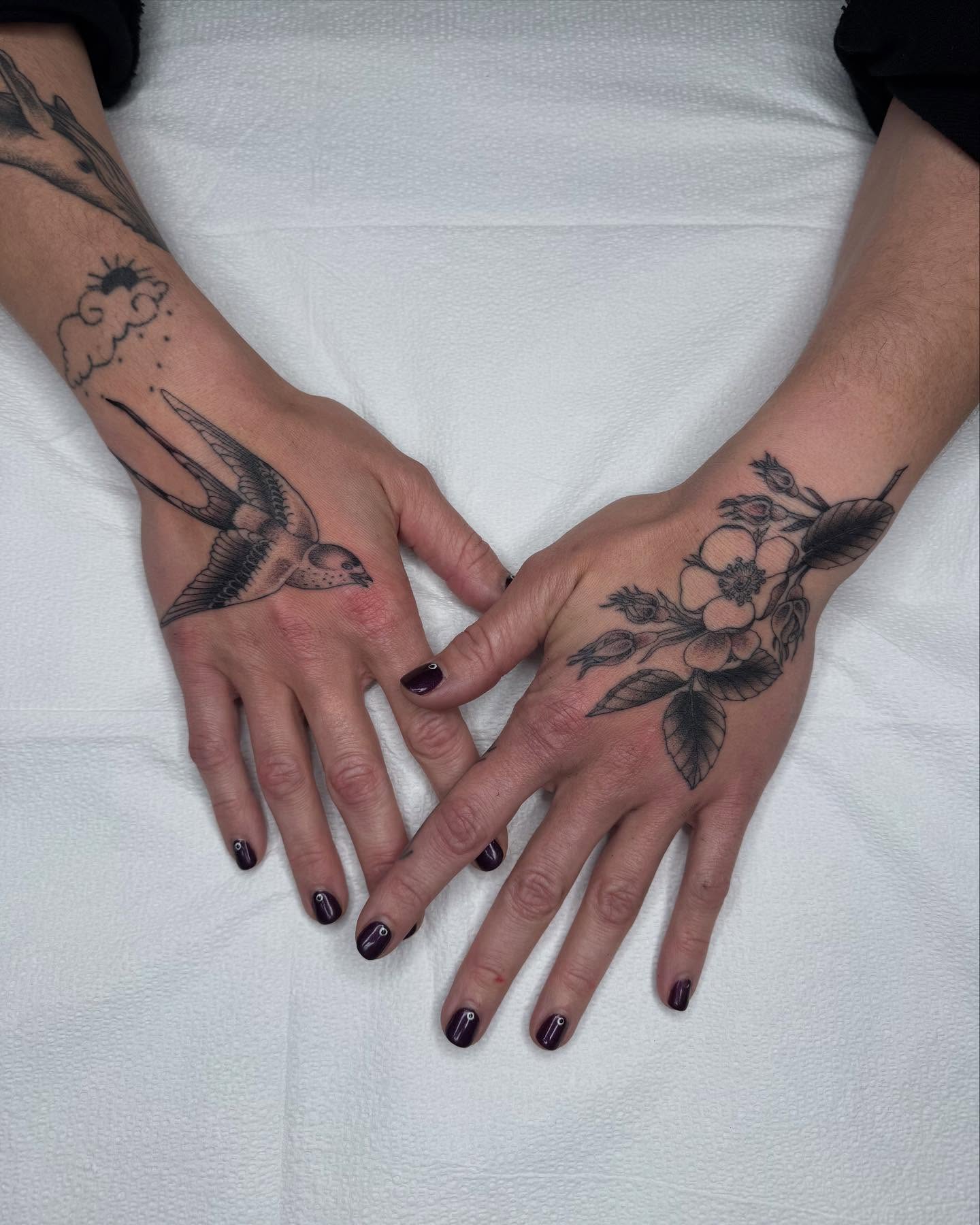 Bird and flower black and grey tattoo on the hand by Finley Jordan
