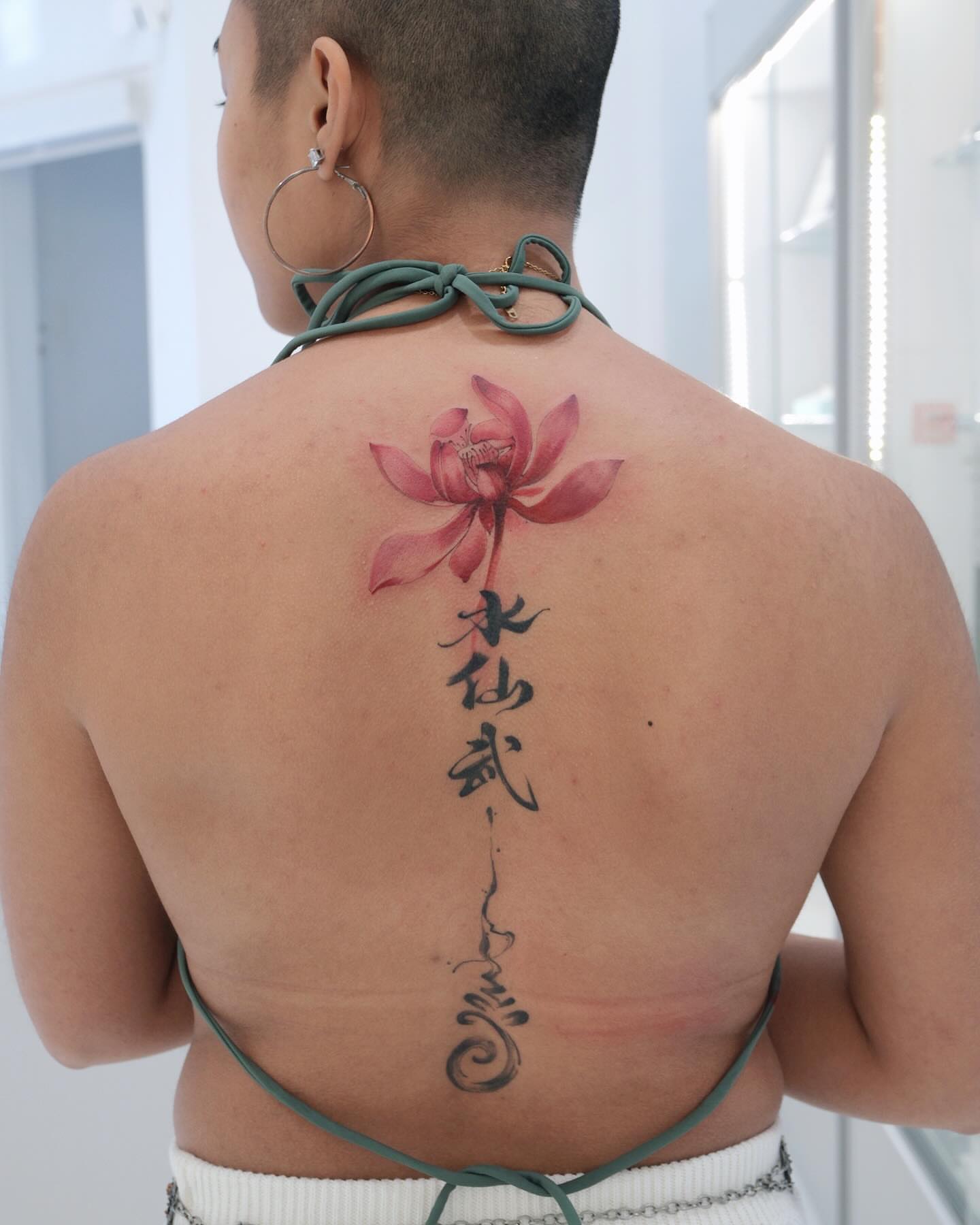Lotus flower watercolor tattoo on the back by MJ tattooist