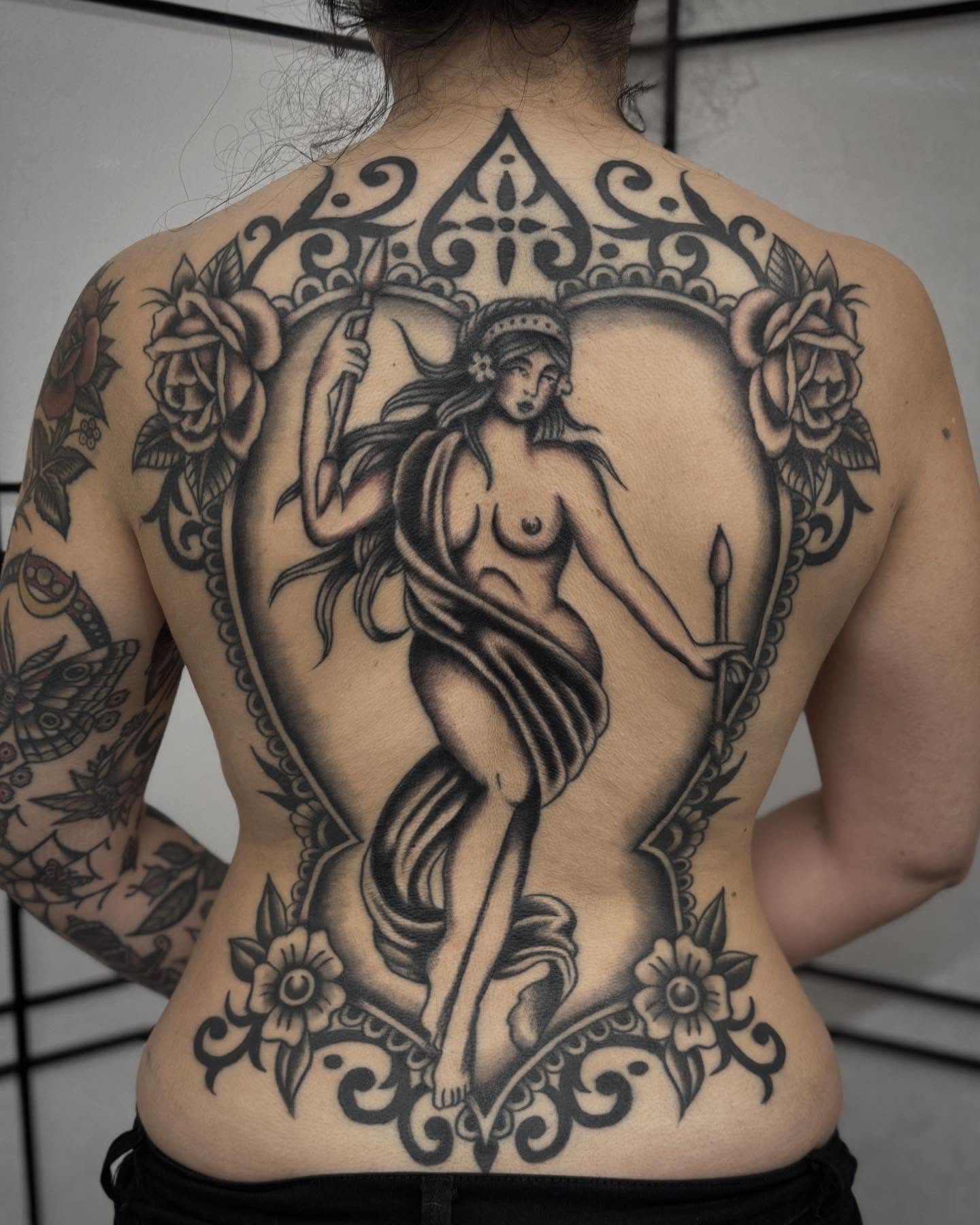 Naked woman with staff black and grey tattoo on the back by Micah Norman, San Francisco, California